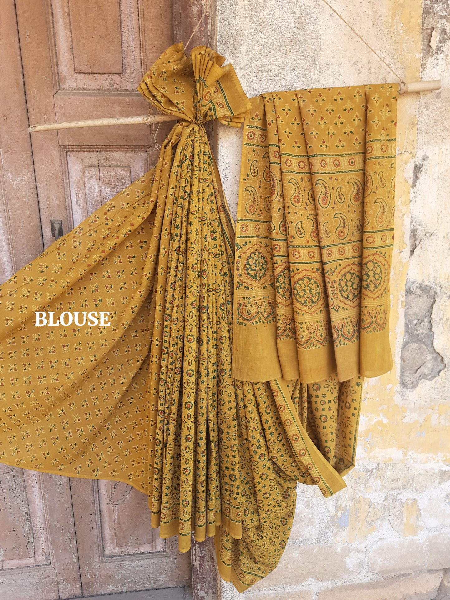 Turmeric dyed Ajrakh hand block printed cotton saree crafted using traditional wooden blocks. Natural dyed, breathable and slow made saree featuring intricate Ajrakh patterns with a running blouse piece, handmade by artisans in Gujarat.