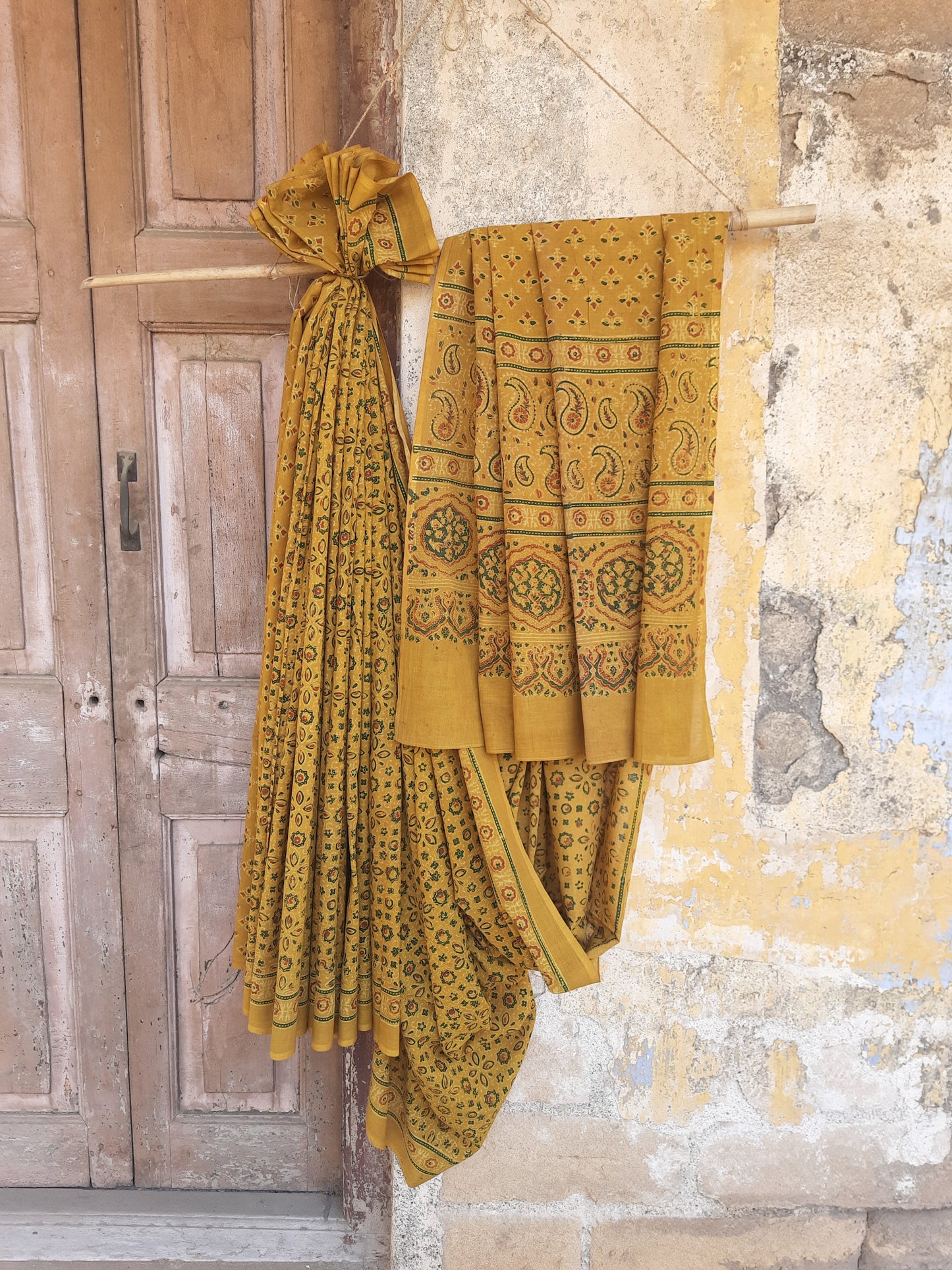 Turmeric dyed Ajrakh hand block printed cotton saree crafted using traditional wooden blocks. Natural dyed, breathable and slow made saree featuring intricate Ajrakh patterns with a running blouse piece, handmade by artisans in Gujarat.