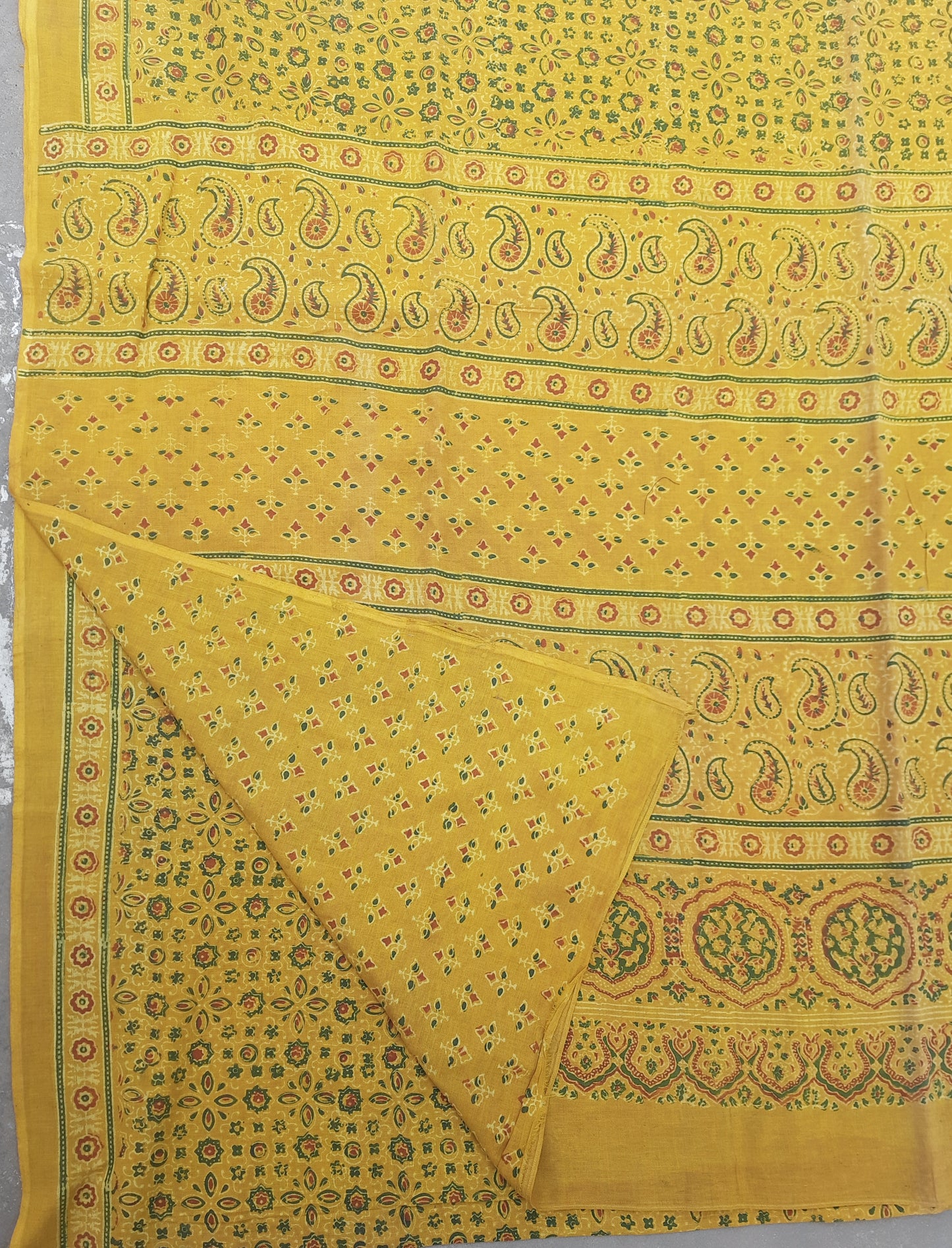 Turmeric dyed Ajrakh hand block printed cotton saree crafted using traditional wooden blocks. Natural dyed, breathable and slow made saree featuring intricate Ajrakh patterns with a running blouse piece, handmade by artisans in Gujarat.
