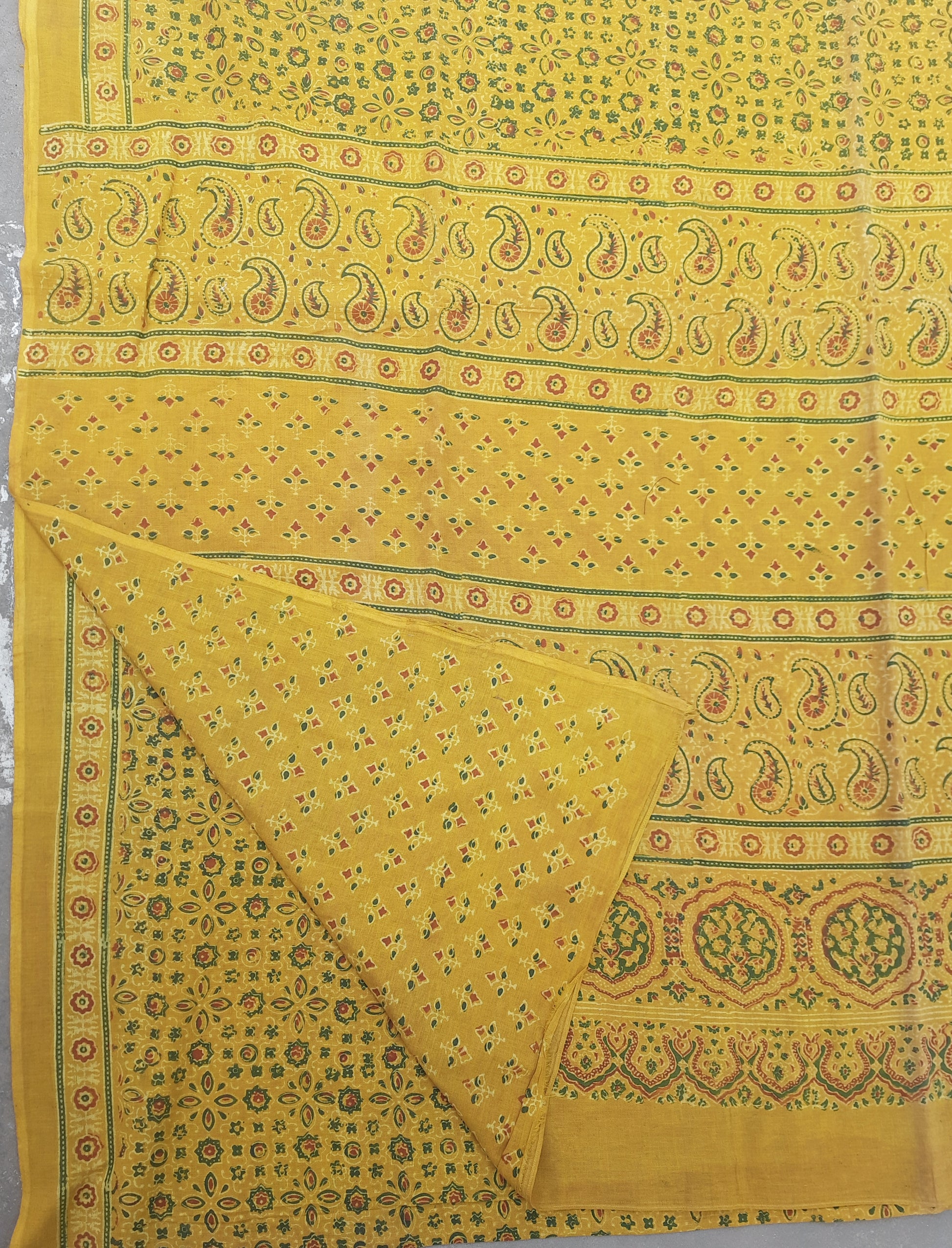 Turmeric dyed Ajrakh hand block printed cotton saree crafted using traditional wooden blocks. Natural dyed, breathable and slow made saree featuring intricate Ajrakh patterns with a running blouse piece, handmade by artisans in Gujarat.