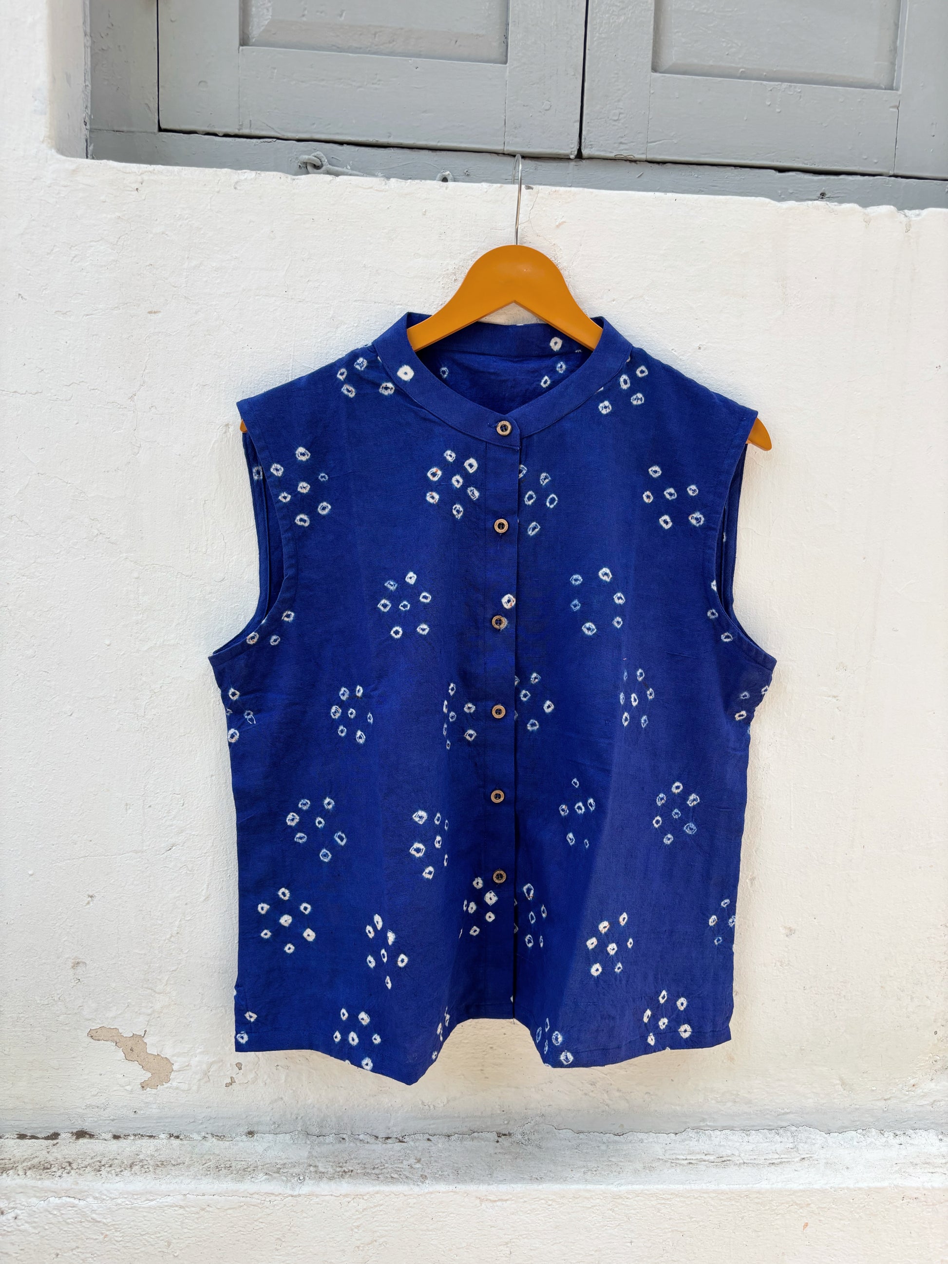 Handspun and handwoven organic cotton sleeveless Bandhani shirt in dusty royal blue with soft mandarin collar, side slits, and relaxed fit.