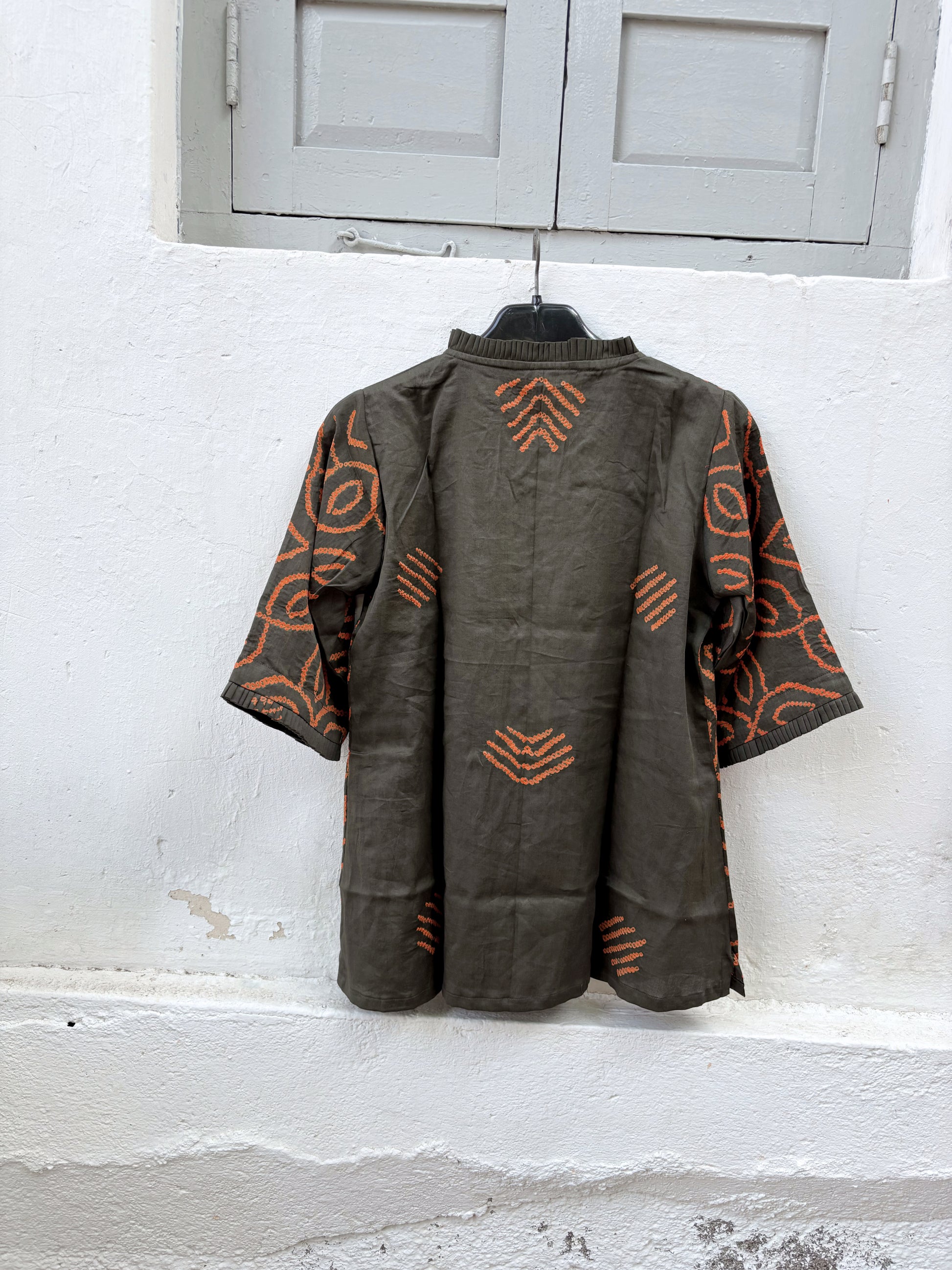 Jhankar Bandhani cotton shirt in smoky charcoal grey with burnt rust orange floral motifs, pleated neckline, pleated sleeve hems, coconut shell buttons, and relaxed fit.