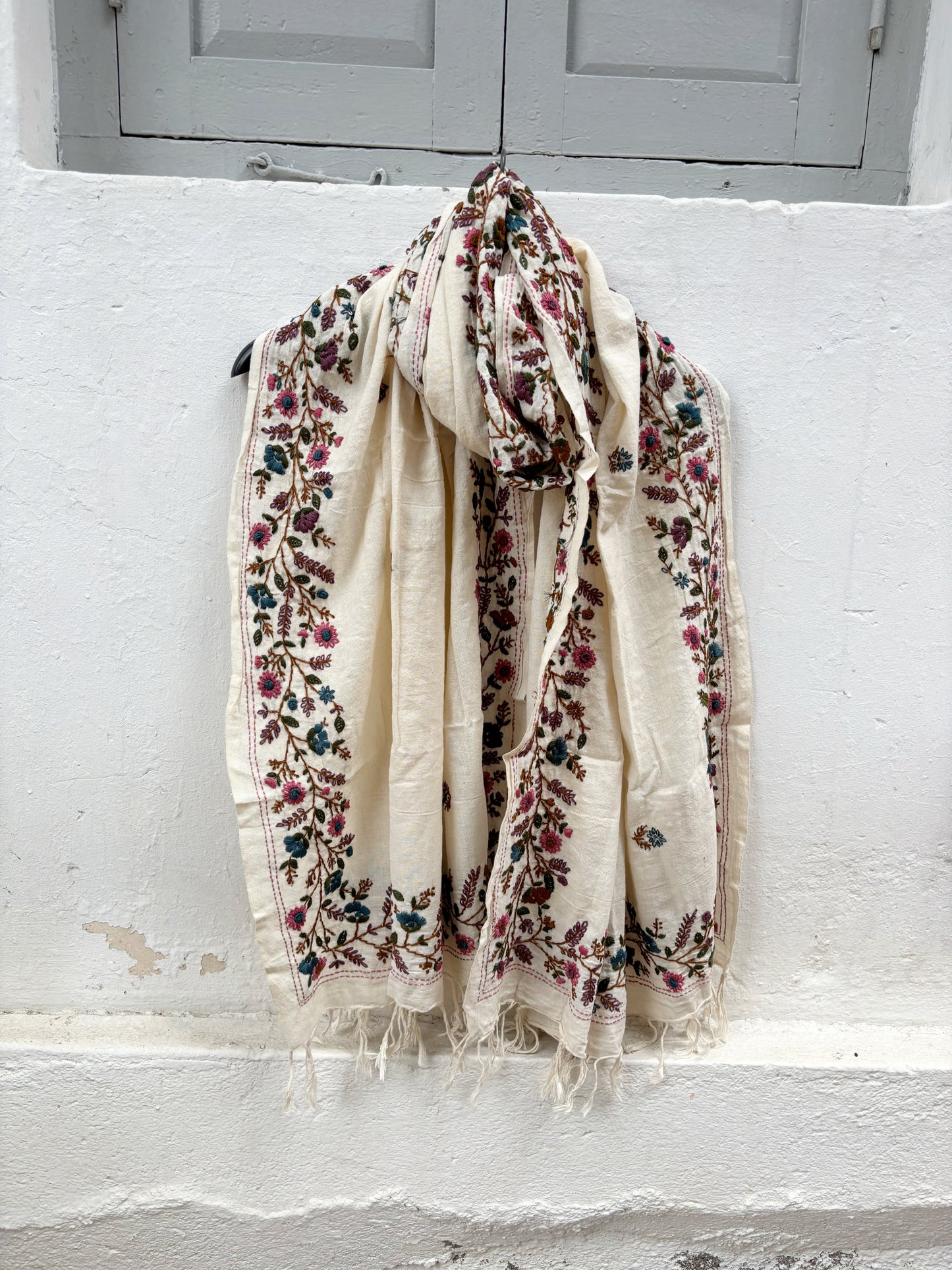 Bela hand spun handwoven off-white cotton dupatta with multicolour floral hand embroidered borders, scattered floral butis, and handcrafted tassels.