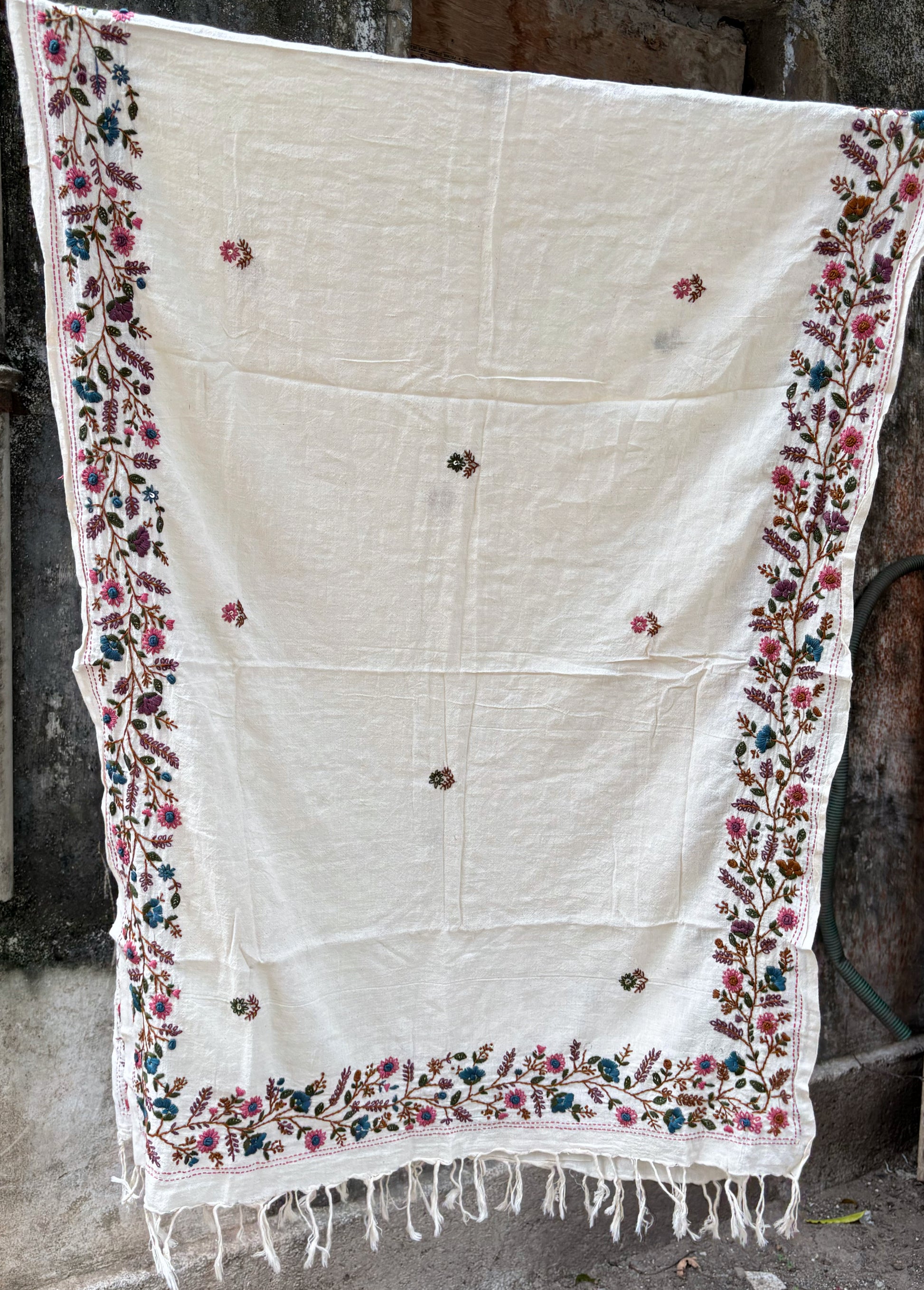 Bela hand spun handwoven off-white cotton dupatta with multicolour floral hand embroidered borders, scattered floral butis, and handcrafted tassels.