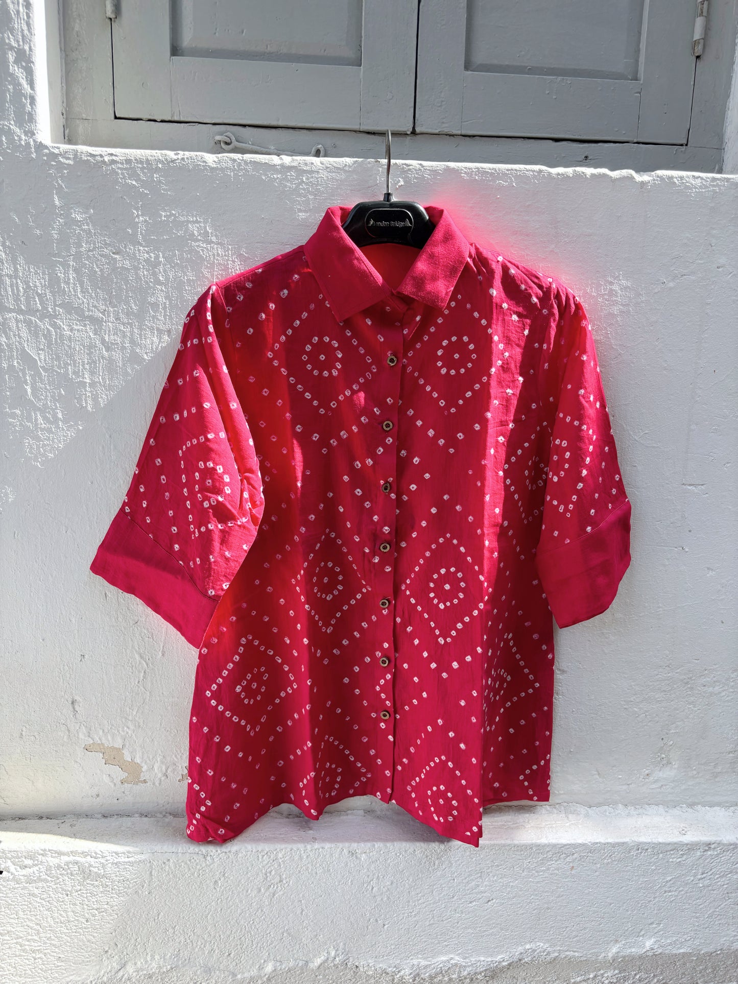 Hand tie-dyed Bougainvillea Pink Bandhani cotton satin shirt with geometric white Bandhani motifs and a classic shirt collar.
