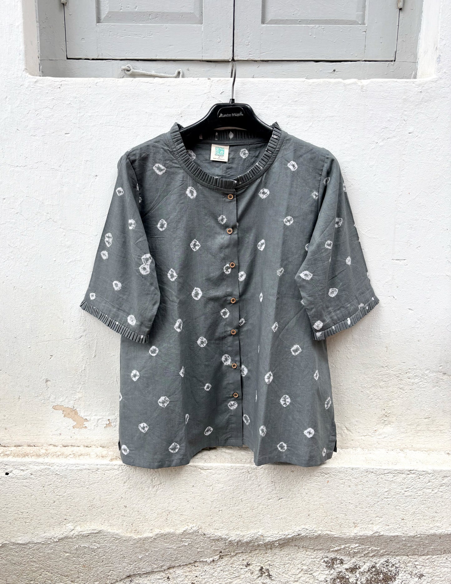 Charcoal grey cotton Bandhani shirt with pleated sleeve hems and wooden buttons.