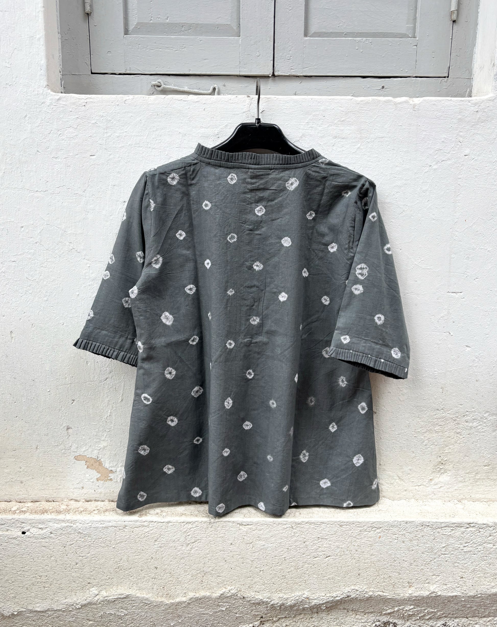 Charcoal grey cotton Bandhani shirt with pleated sleeve hems and wooden buttons.