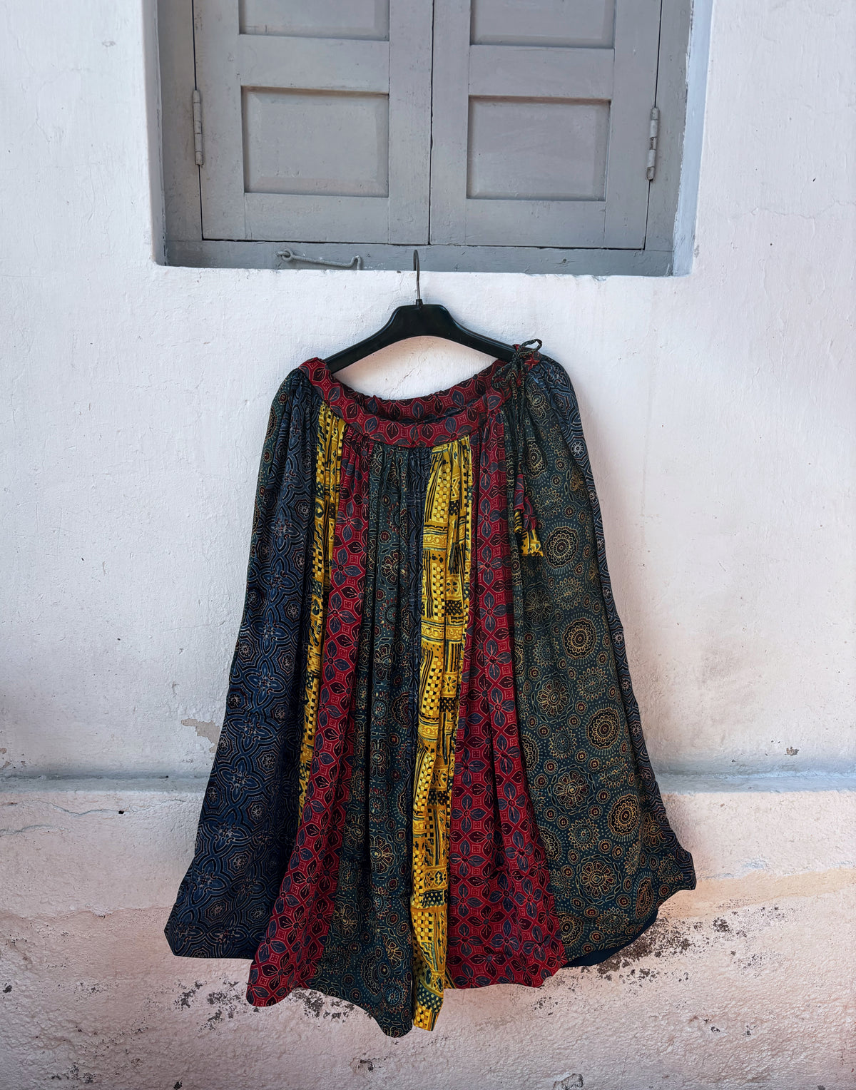 Multi-print natural-dyed Ajrakh modal silk skirt in indigo, wine red and mustard yellow, styled with an ivory sleeveless top
