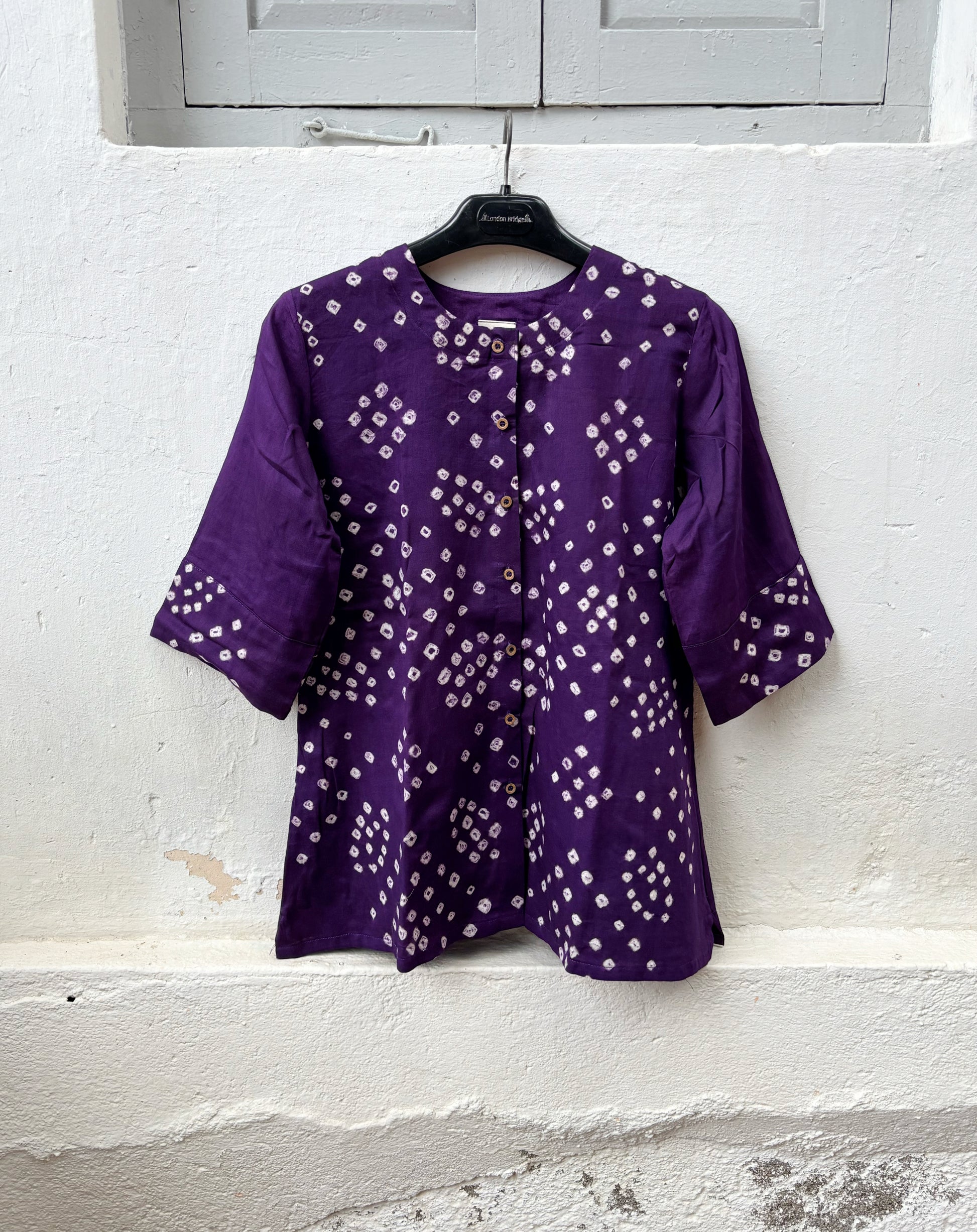 Deep Aubergine Cotton Satin Bandhani Shirt with hand tie-dyed geometric motifs, round neck, wooden buttons, relaxed fit, and elbow-length sleeves.