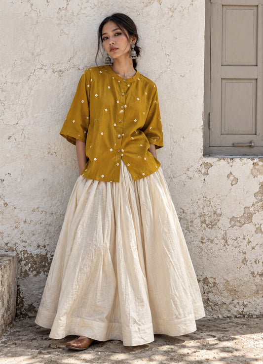 Mustard-ochre Bandhani cotton satin shirt styled with an ivory full-length skirt