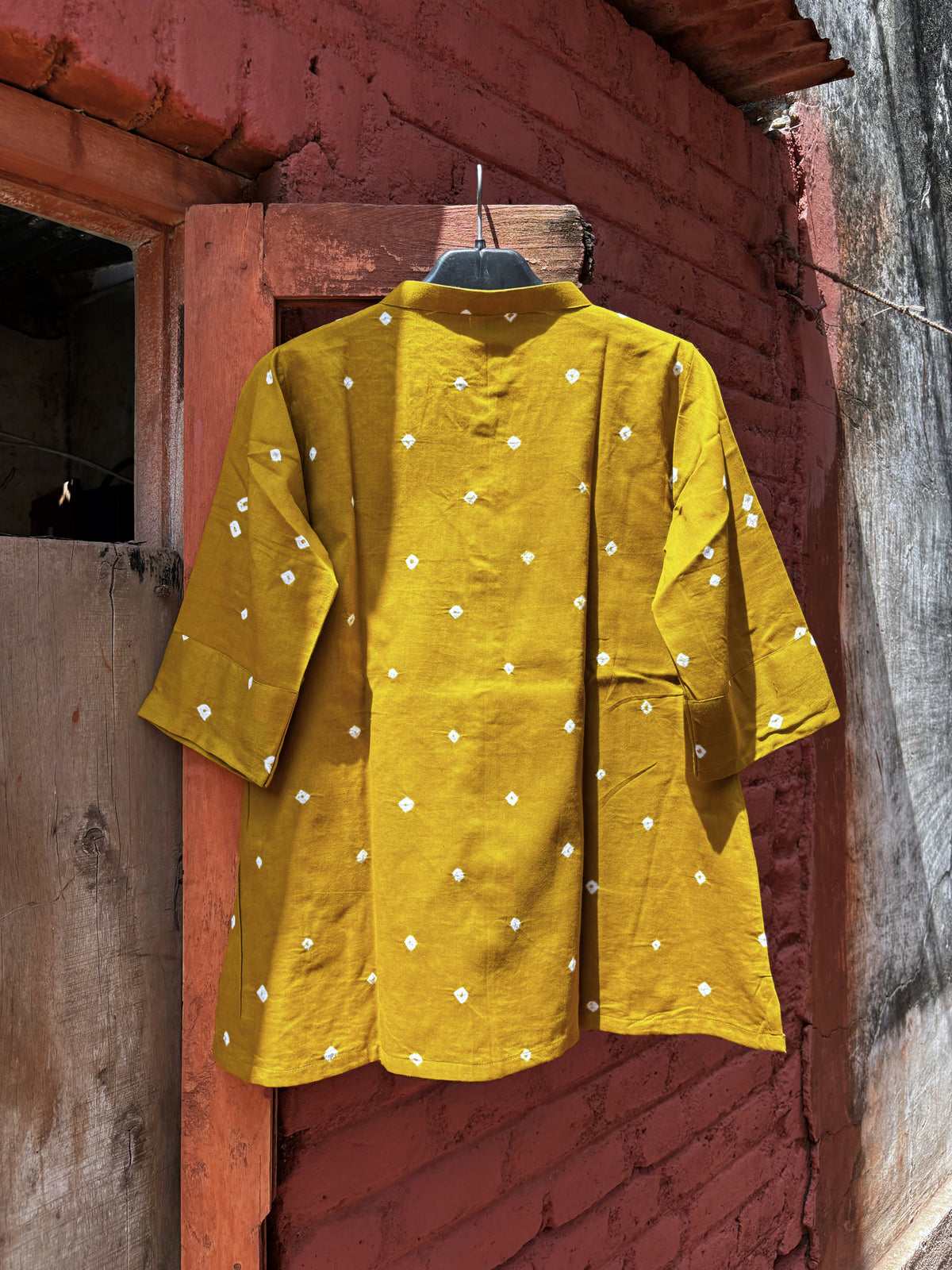 Front view of Tesu mustard-ochre cotton satin shirt with ivory Bandhani motifs, soft mandarin collar and front buttons