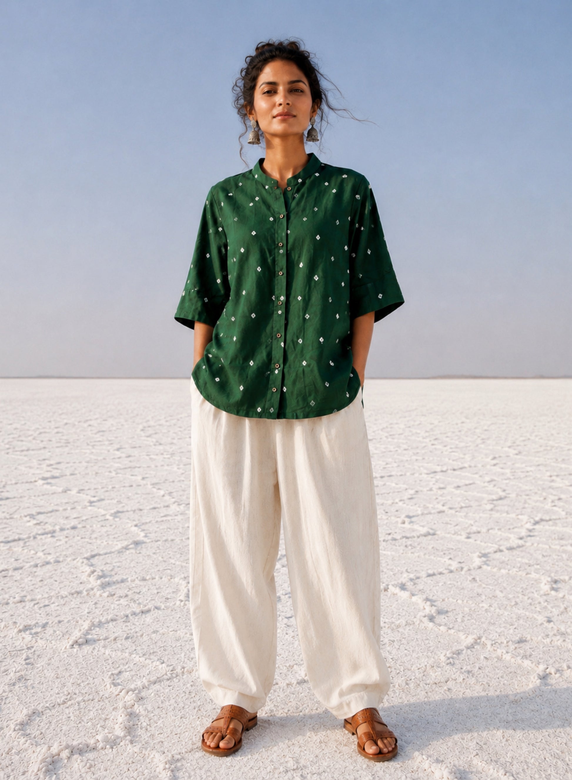 Forest green cotton satin Bandhani shirt with hand tie-dyed white motifs, soft mandarin collar, coconut shell buttons, elbow-length sleeves, and relaxed fit.