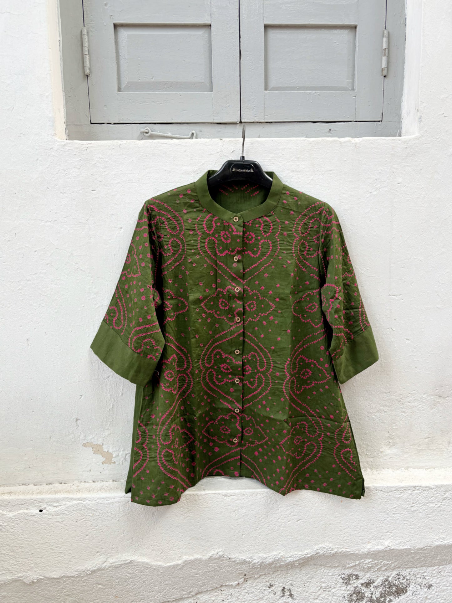 Forest olive green Jhankar Bandhani cotton shirt with berry pink motifs, soft mandarin collar, folded sleeve cuffs, coconut shell buttons and relaxed fit.