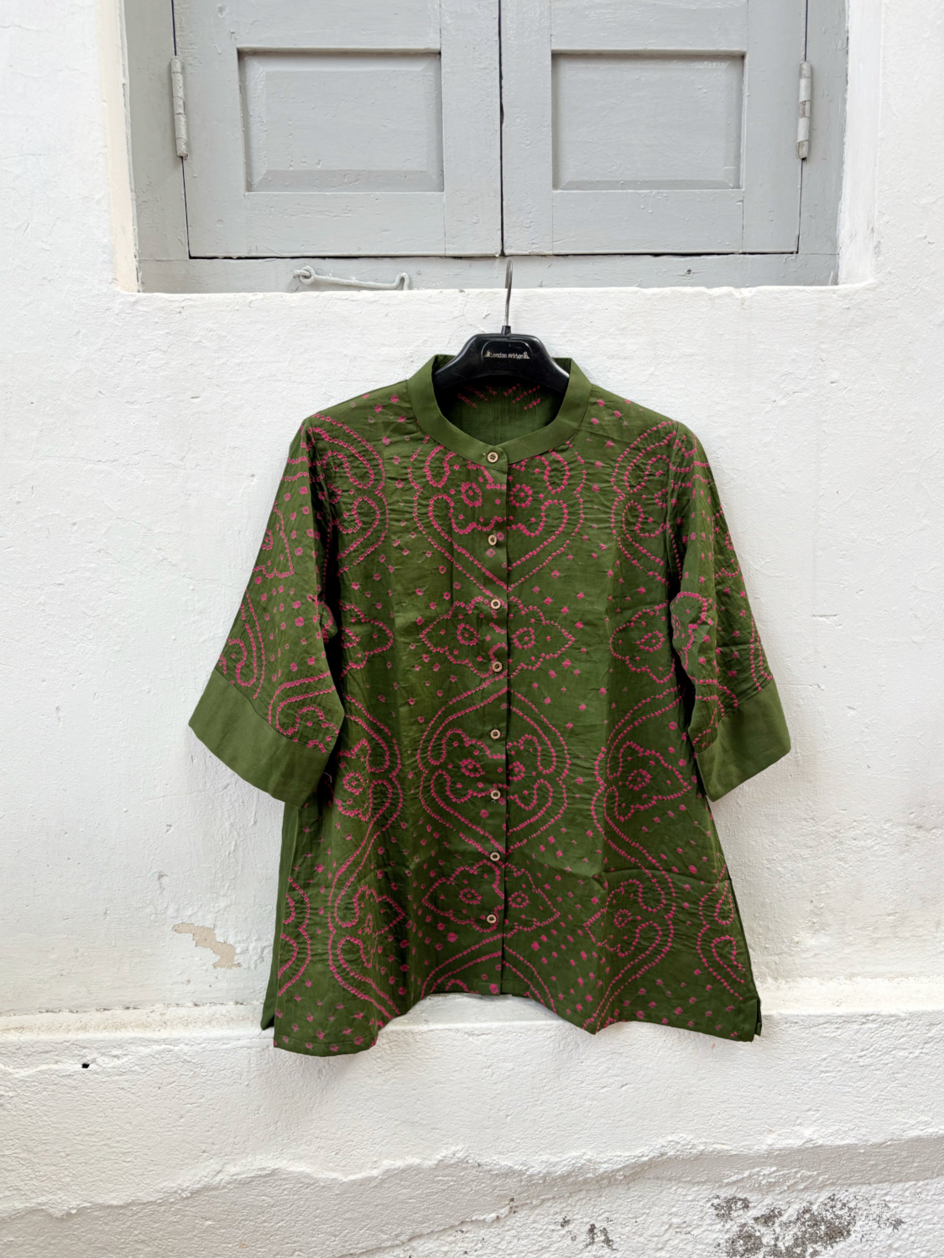 Forest olive green Jhankar Bandhani cotton shirt with berry pink motifs, soft mandarin collar, folded sleeve cuffs, coconut shell buttons and relaxed fit.