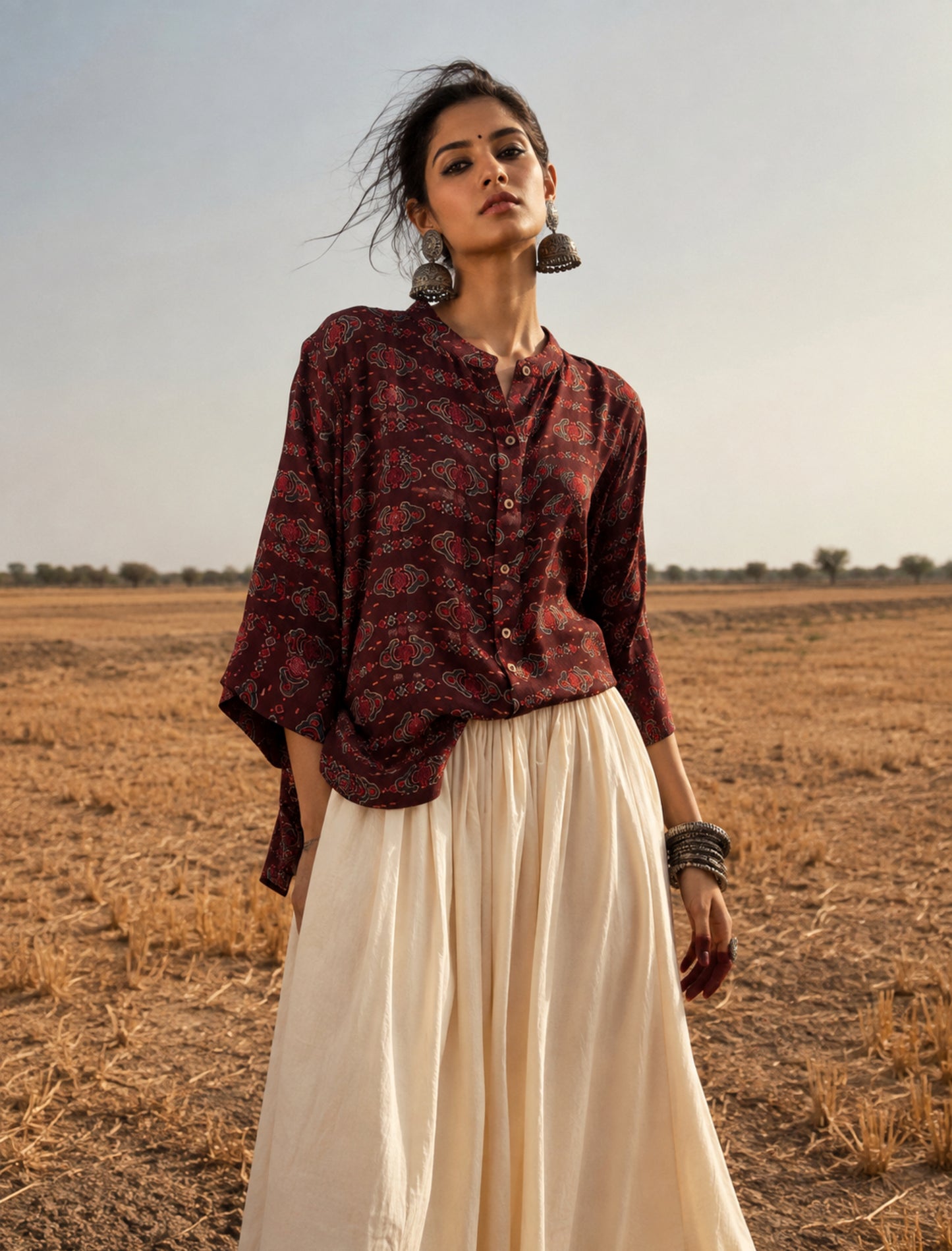Woman wearing Gheru natural dyed Ajrakh modal silk oversized shirt with traditional handcrafted motifs.