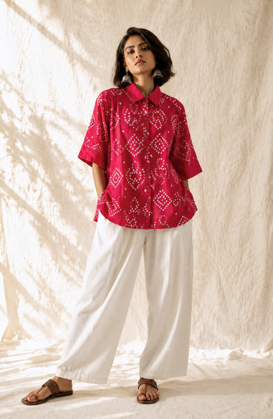 Handmade bougainvillea pink Bandhani cotton satin shirt with geometric motifs, classic collar and relaxed fit.