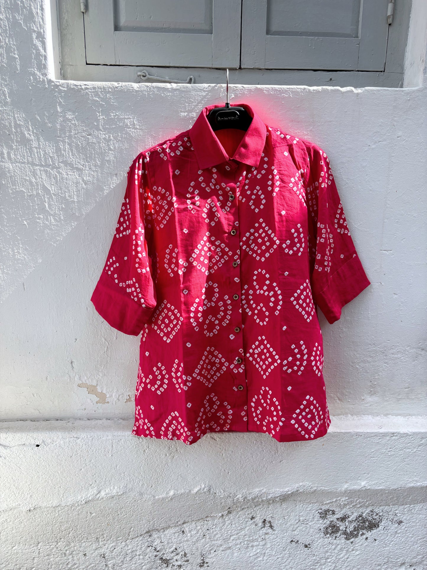 Handmade bougainvillea pink Bandhani cotton satin shirt with geometric motifs, classic collar and relaxed fit.