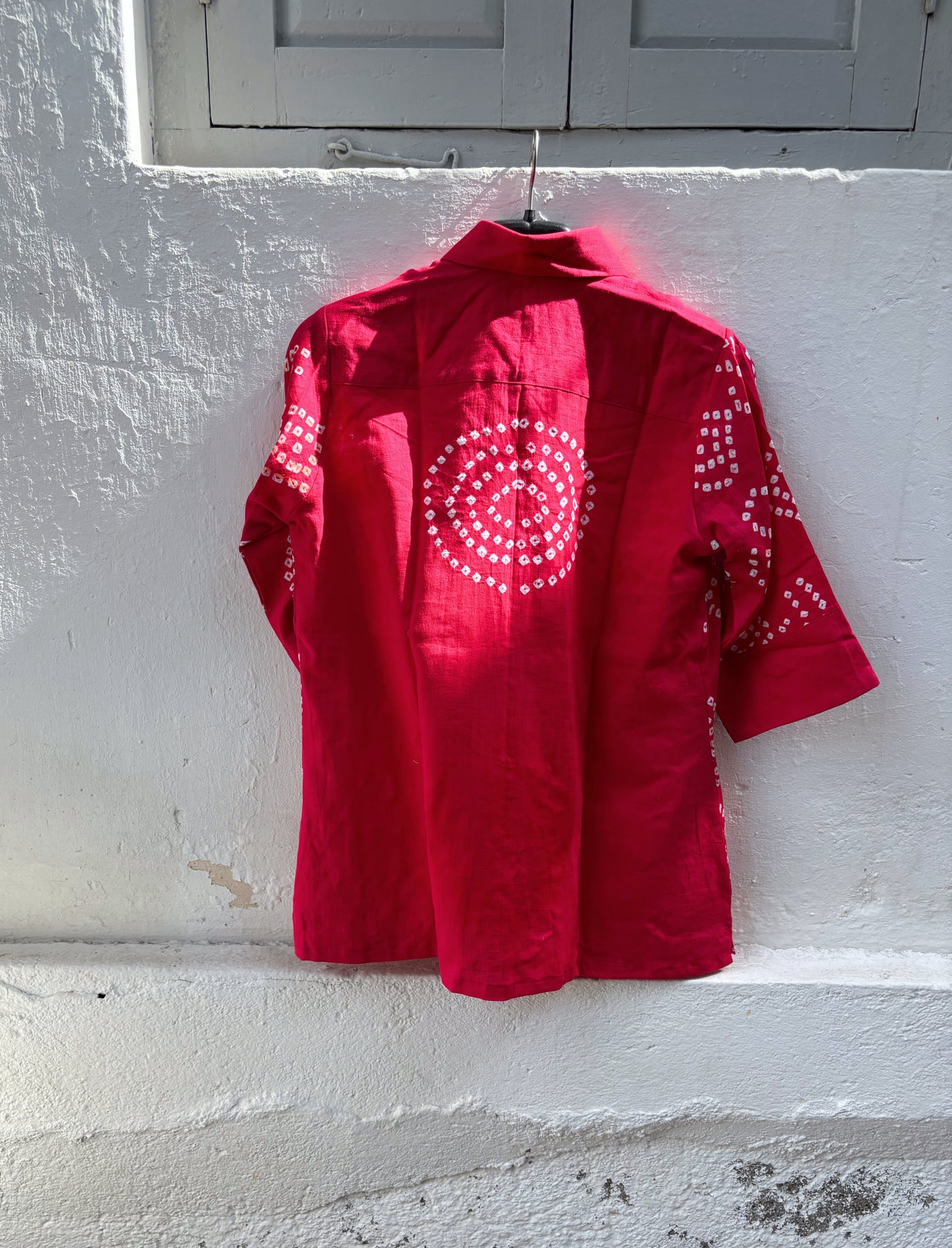 Handmade bougainvillea pink Bandhani cotton satin shirt with geometric motifs, classic collar and relaxed fit.