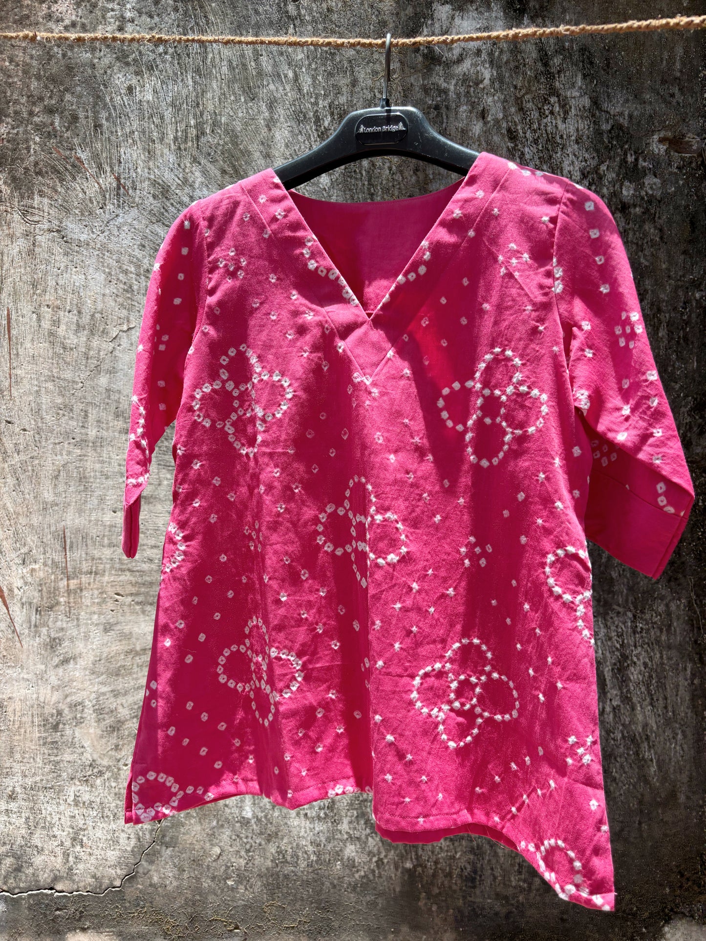 Pink Bandhani V-neck top for women with floral motifs in front and round design at back, hand tie dyed on cotton satin