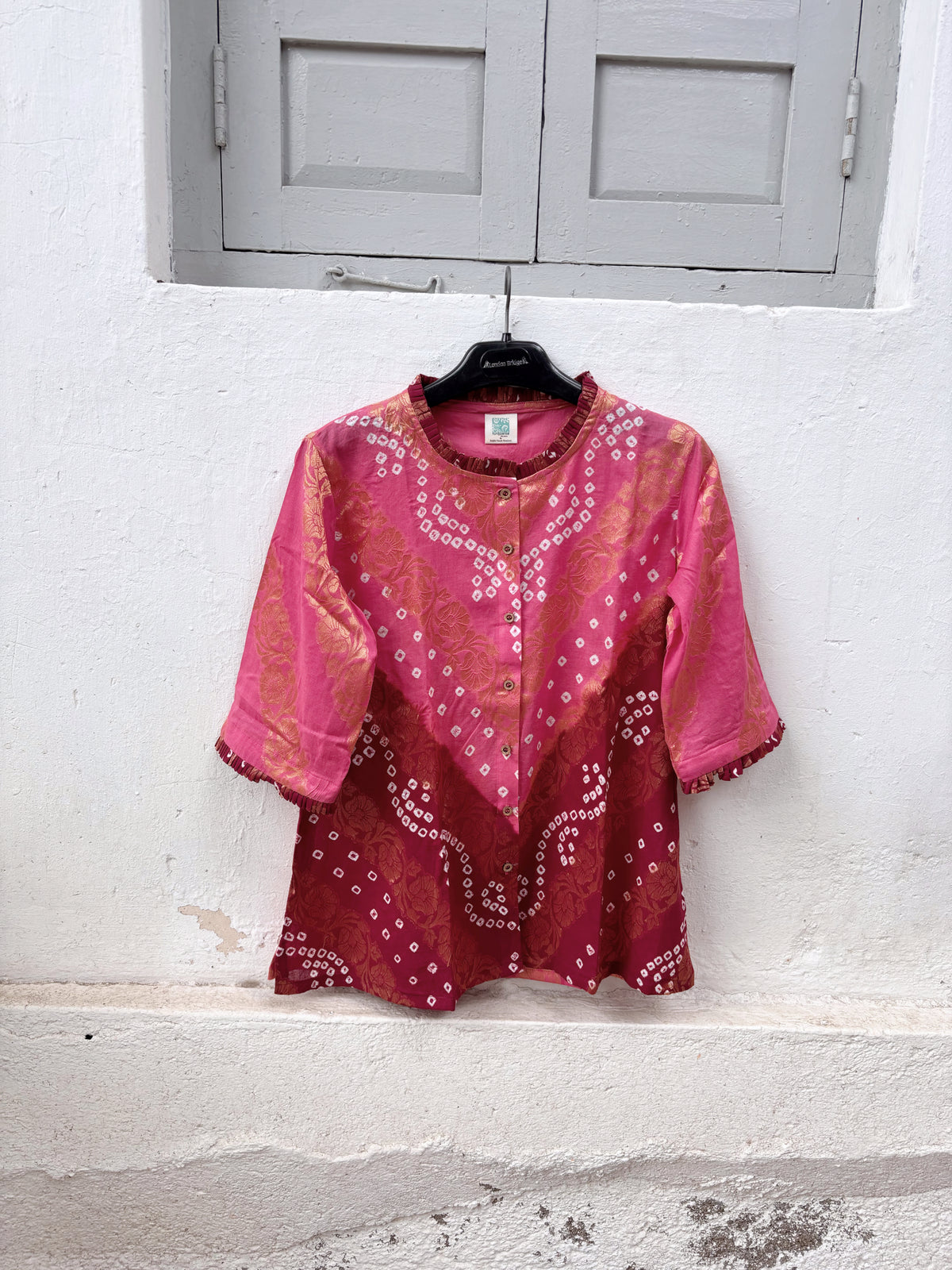 Gulabi is a dusty rose and maroon wine Bandhani cotton shirt with ivory hand-tied Bandhani, antique-gold Banarasi weaves and pleated detailing.