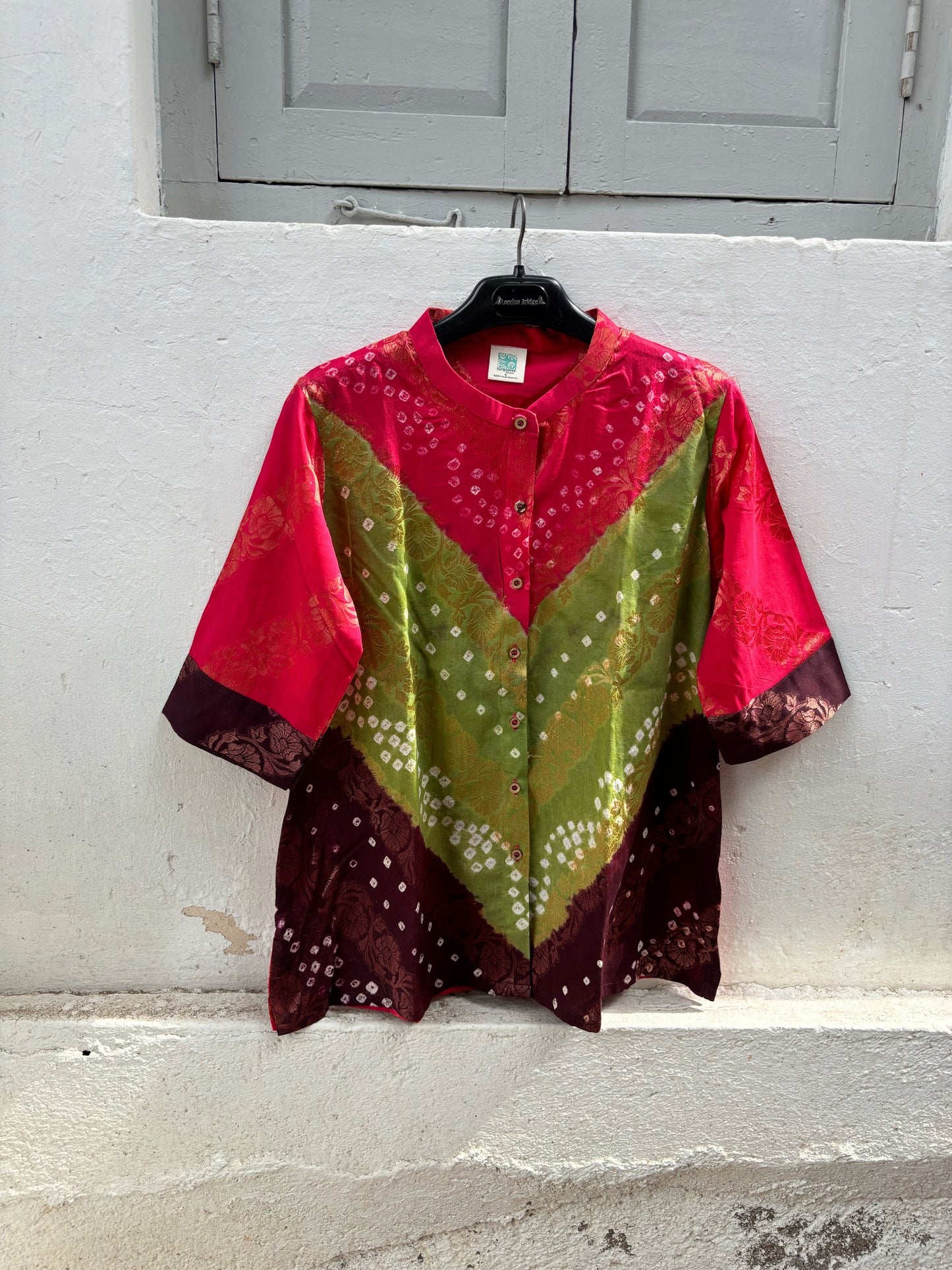 Handcrafted Bandhani festive cotton shirt in Rani Pink, Olive Green and Deep Wine Maroon with antique gold woven floral motifs, round band neckline, short button placket, relaxed fit and three-quarter sleeves.