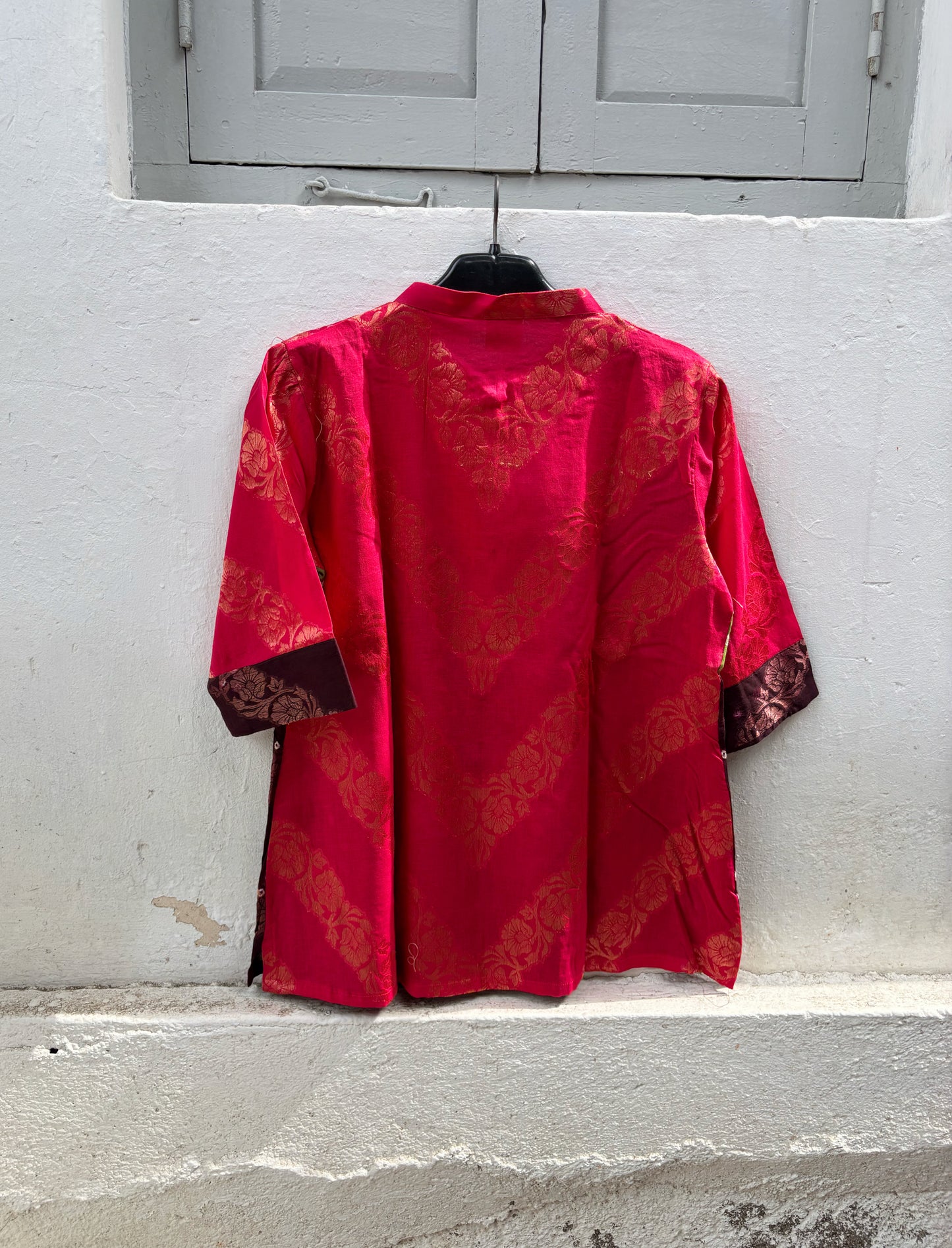 Handcrafted Bandhani festive cotton shirt in Rani Pink, Olive Green and Deep Wine Maroon with antique gold woven floral motifs, round band neckline, short button placket, relaxed fit and three-quarter sleeves.
