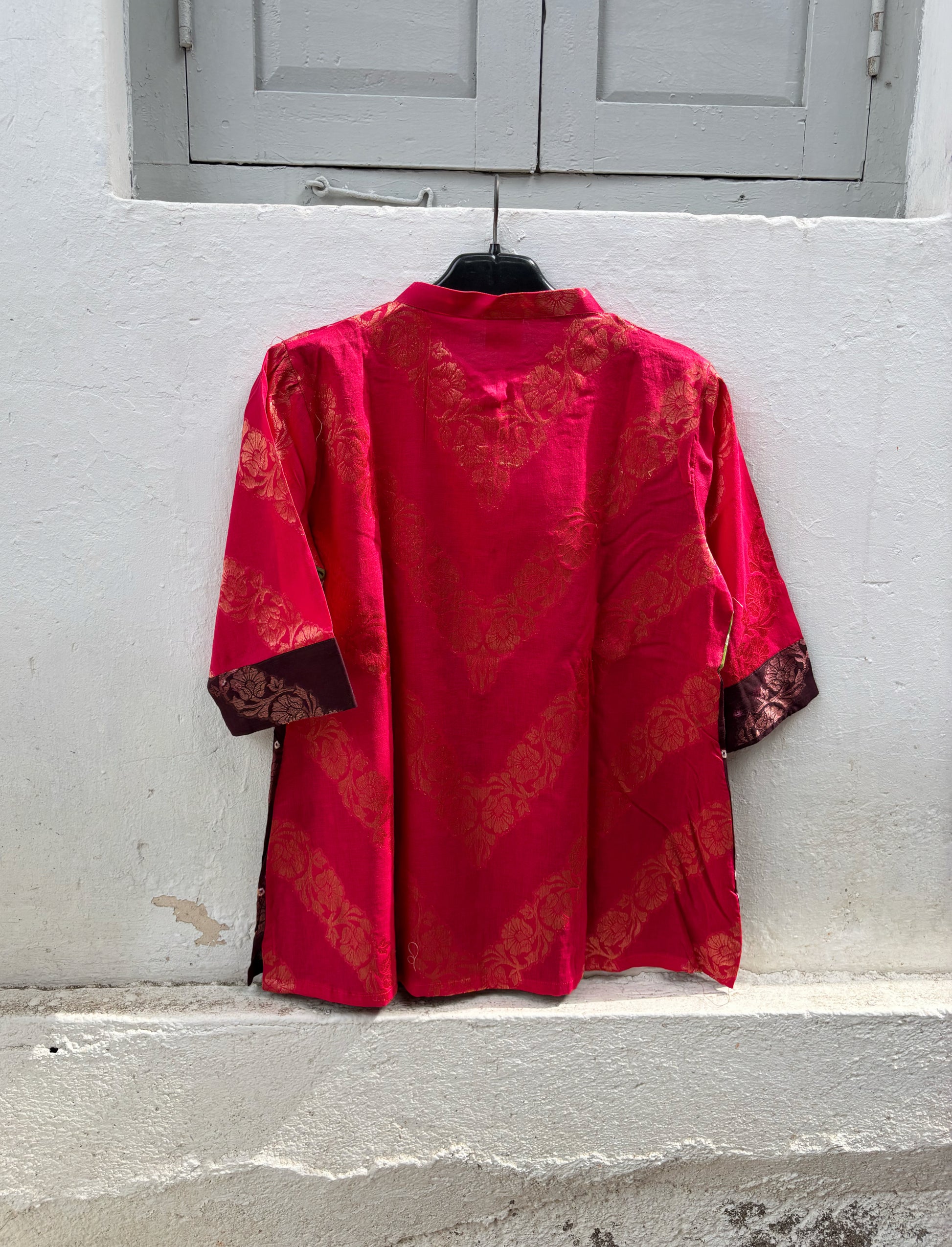 Handcrafted Bandhani festive cotton shirt in Rani Pink, Olive Green and Deep Wine Maroon with antique gold woven floral motifs, round band neckline, short button placket, relaxed fit and three-quarter sleeves.
