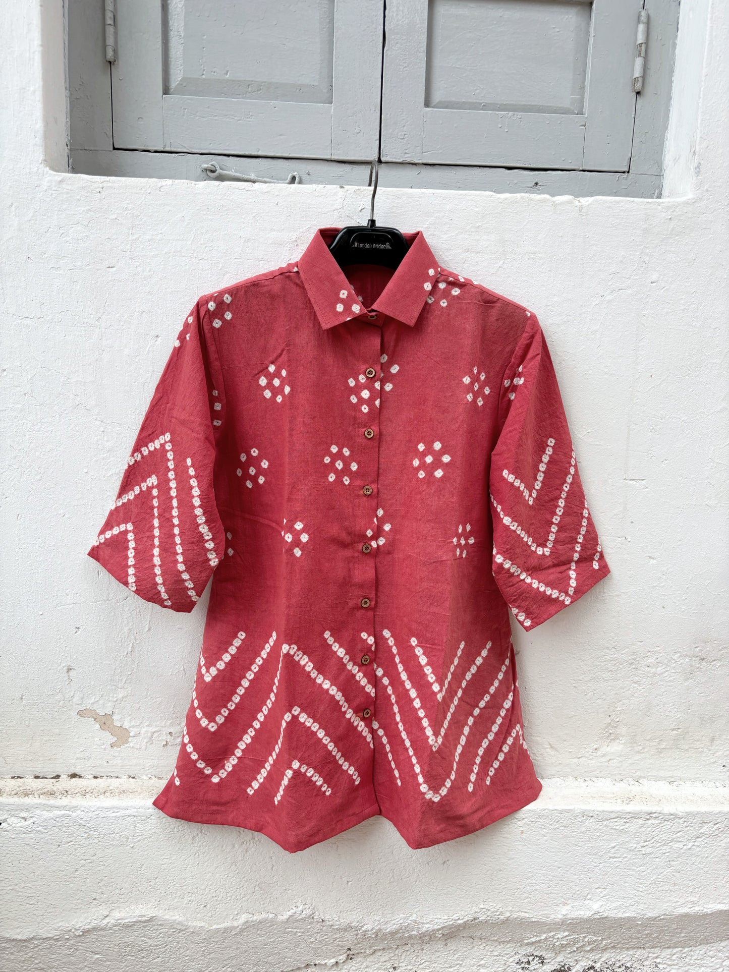 Handspun and handwoven organic cotton Bandhani shirt in muted pomegranate with handcrafted tie-dyed motifs, classic shirt collar, relaxed fit and short side slits.
