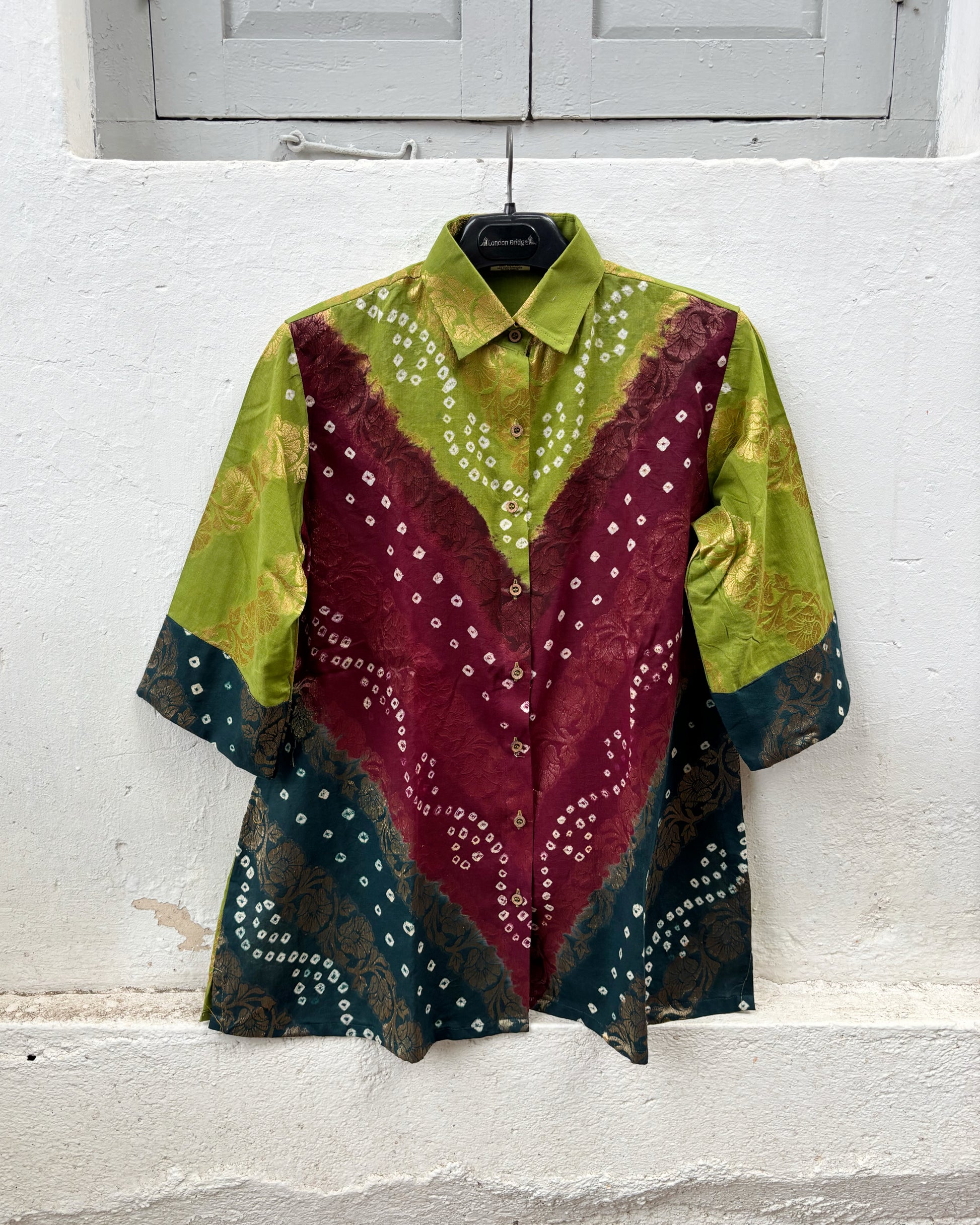 Handcrafted Bandhani festive cotton shirt in Leaf Green, Wine Maroon and Deep Teal with antique gold woven floral motifs, classic shirt collar, front button closure, relaxed fit and three-quarter sleeves.
