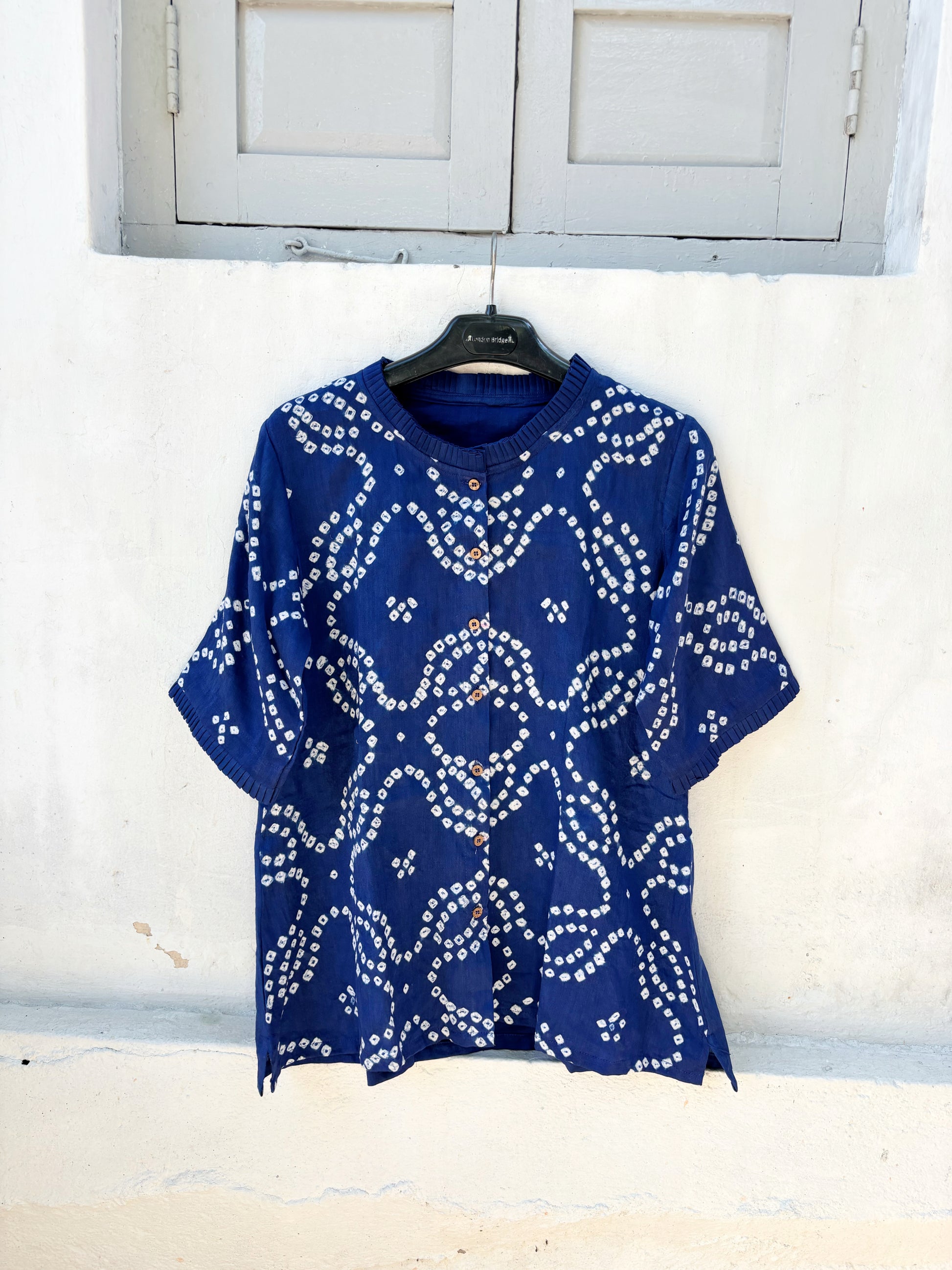 Indigo Bandhani shirt for women with pleated neckline and sleeve hems, hand tie dyed white patterns on cotton satin, relaxed fit.