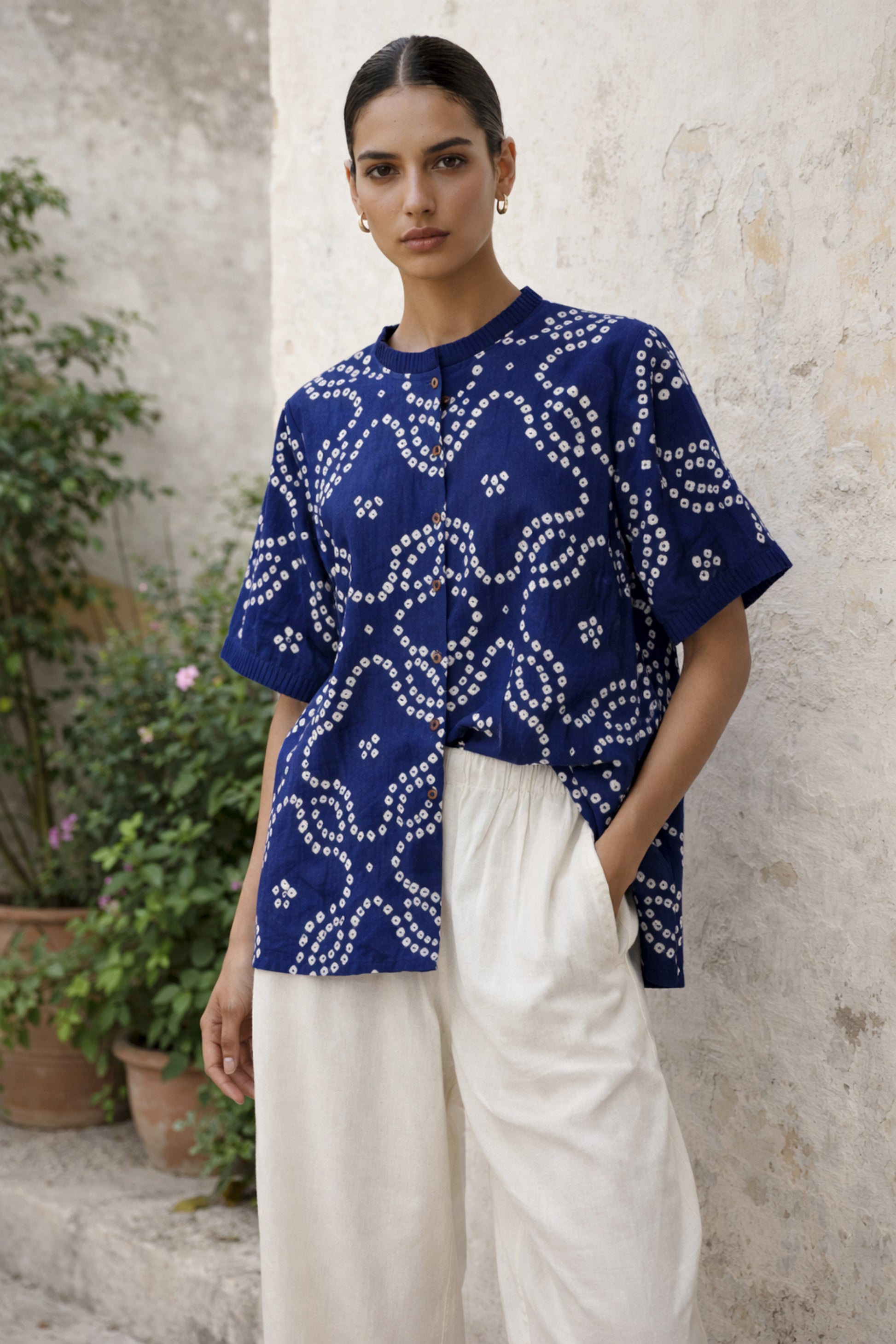 Indigo Bandhani shirt for women with pleated neckline and sleeve hems, hand tie dyed white patterns on cotton satin, relaxed fit.