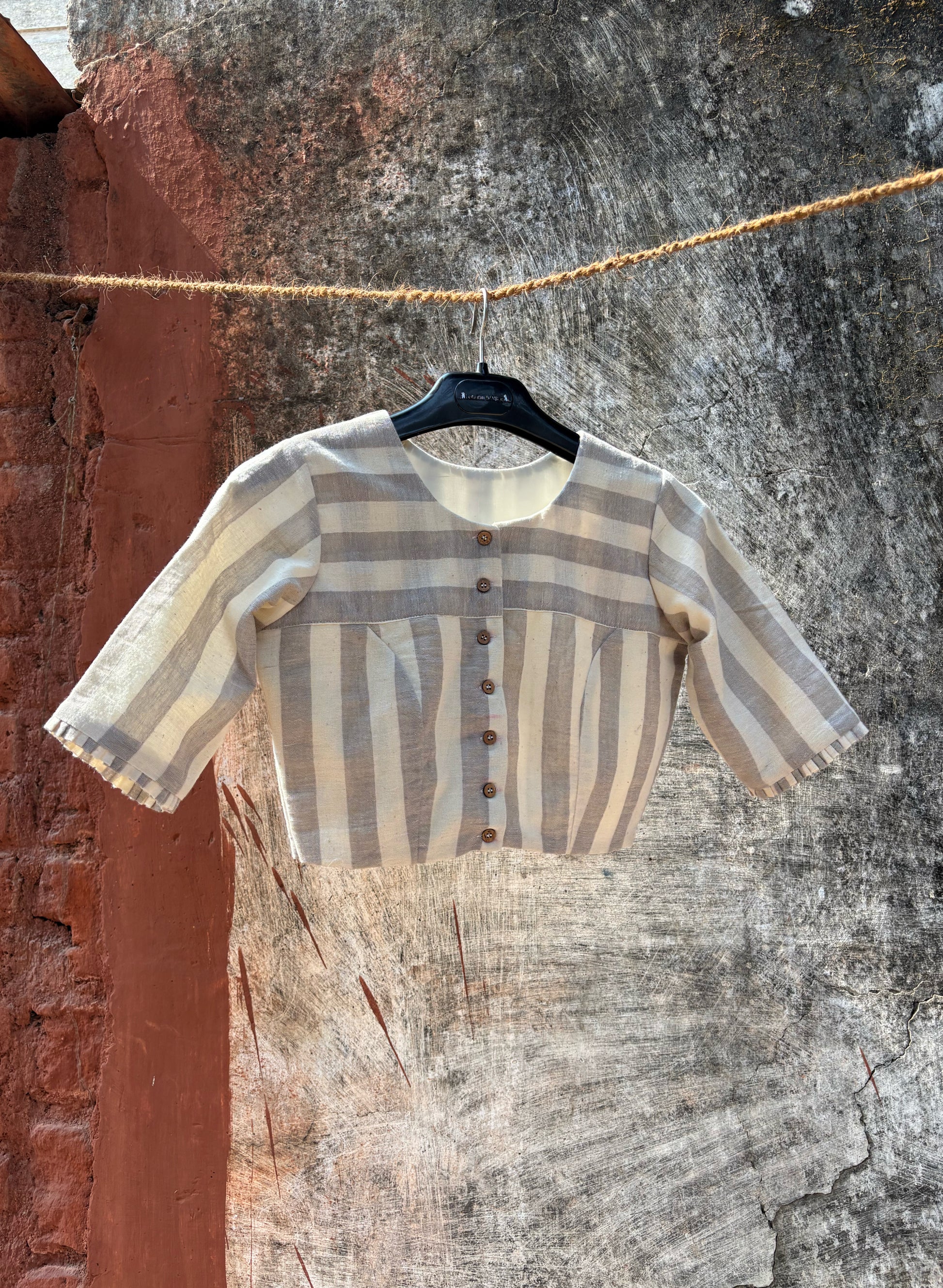 Handspun handwoven organic cotton blouse in ivory and grey stripes with round neck and wooden buttons, slow-made and handmade in India.