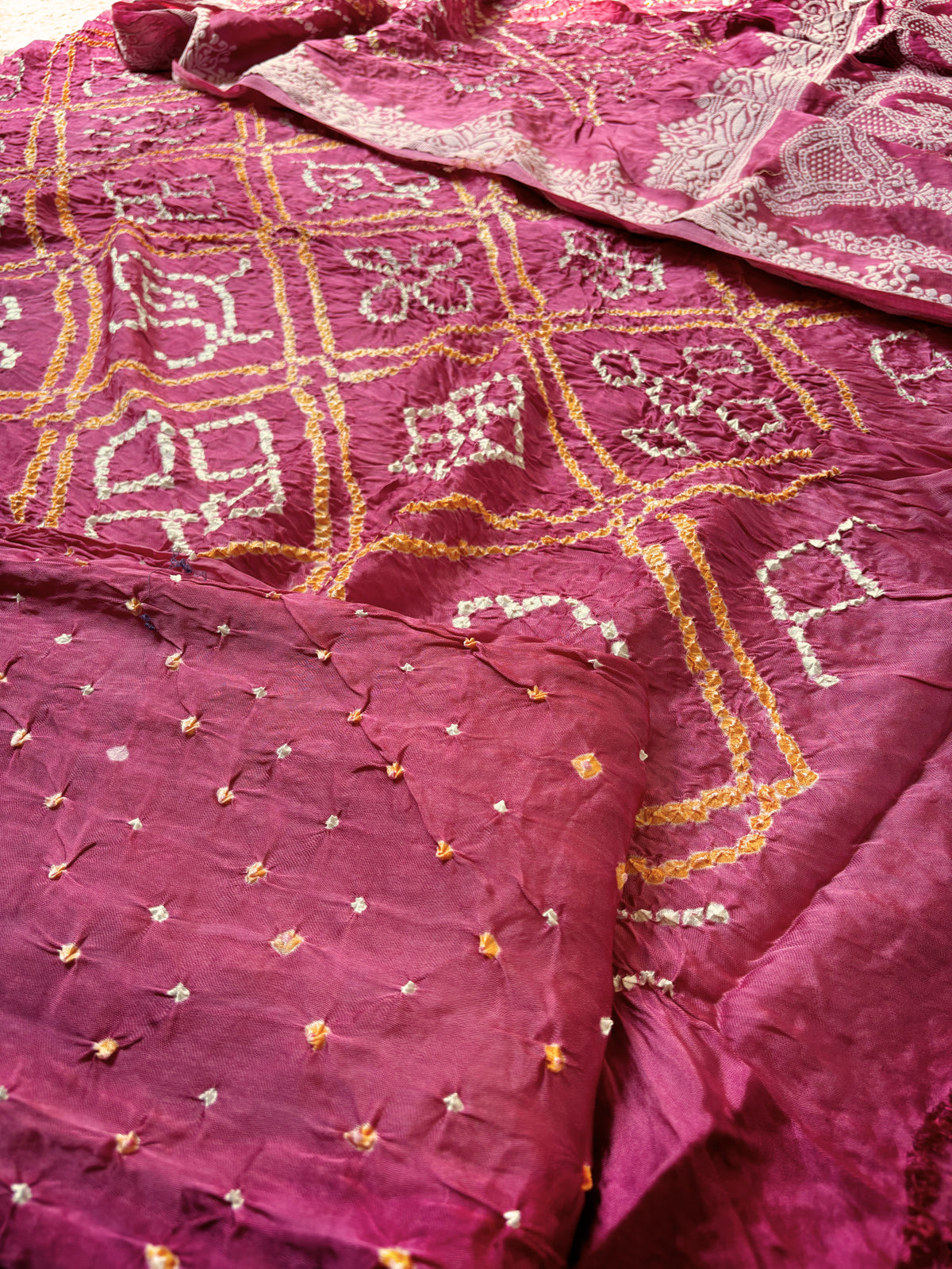 Three-piece muted berry pink modal silk Bandhani unstitched suit set with off-white and mustard-gold motifs.
