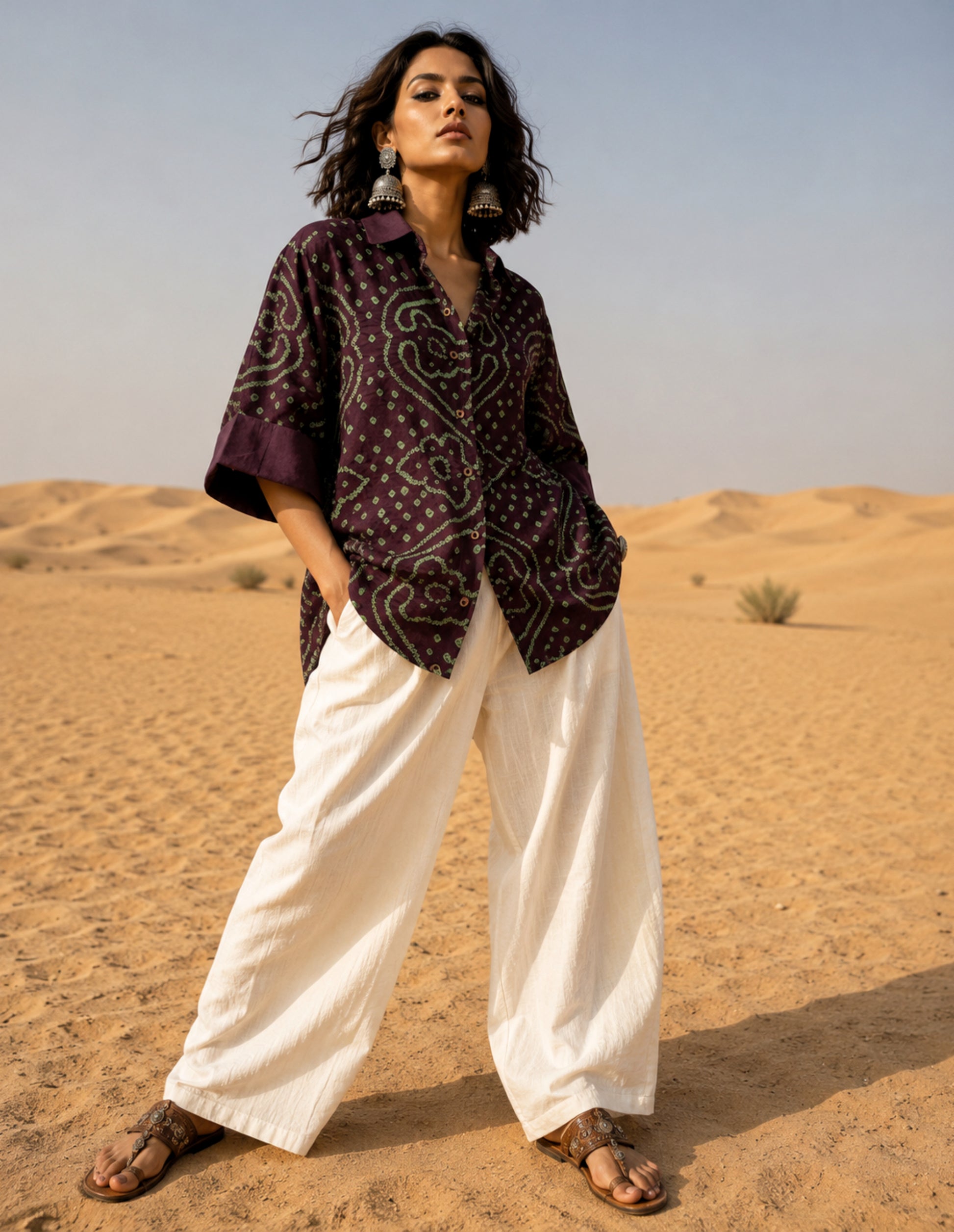 Jhankar Bandhani cotton shirt in deep jamun purple with sage green paisley motifs, classic shirt collar, folded sleeve cuffs, coconut shell buttons, and relaxed fit.