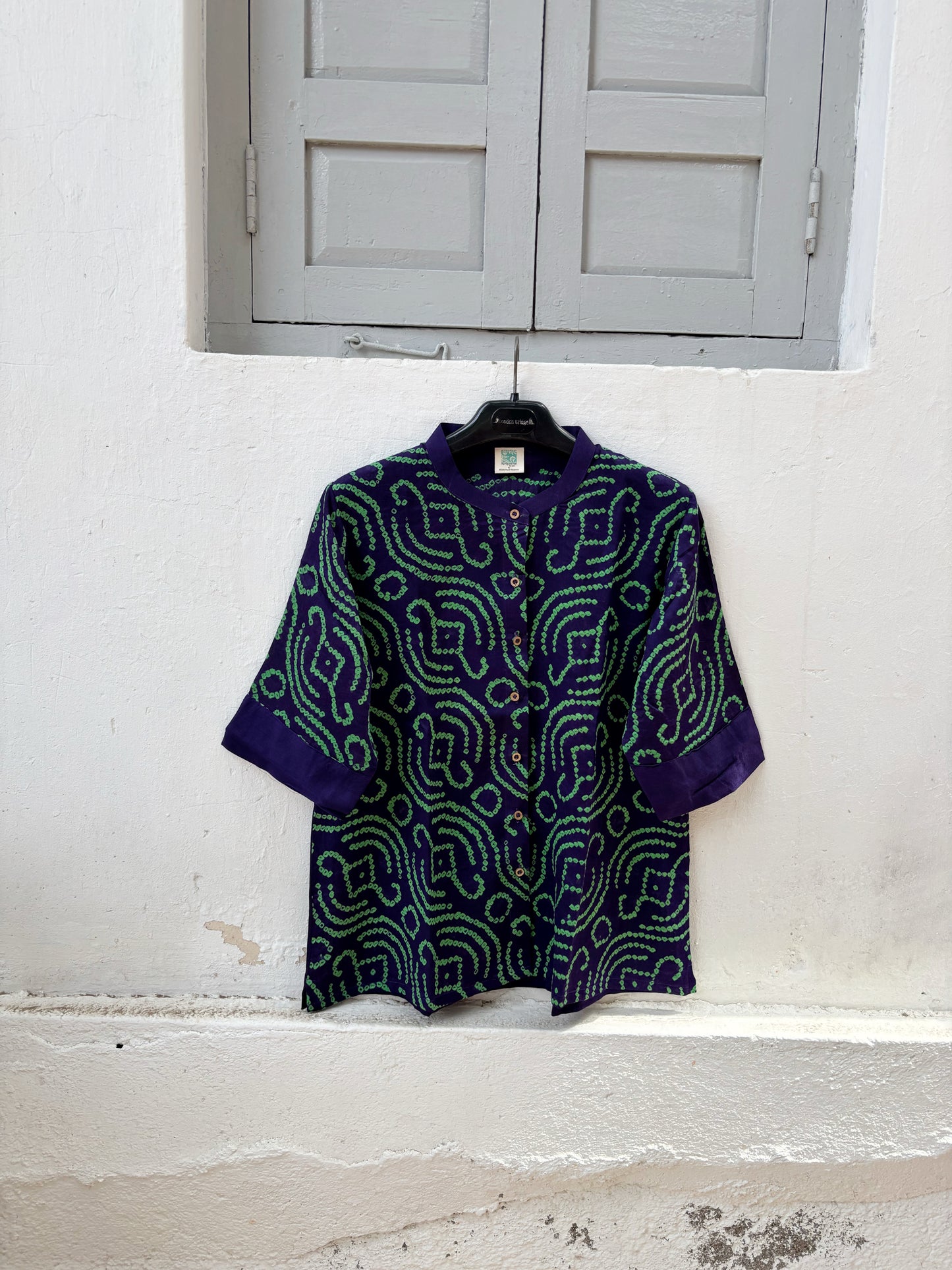 Royal purple Jhankaar Bandhani cotton shirt with vibrant parrot green motifs, soft mandarin collar, folded sleeve cuffs and relaxed fit.