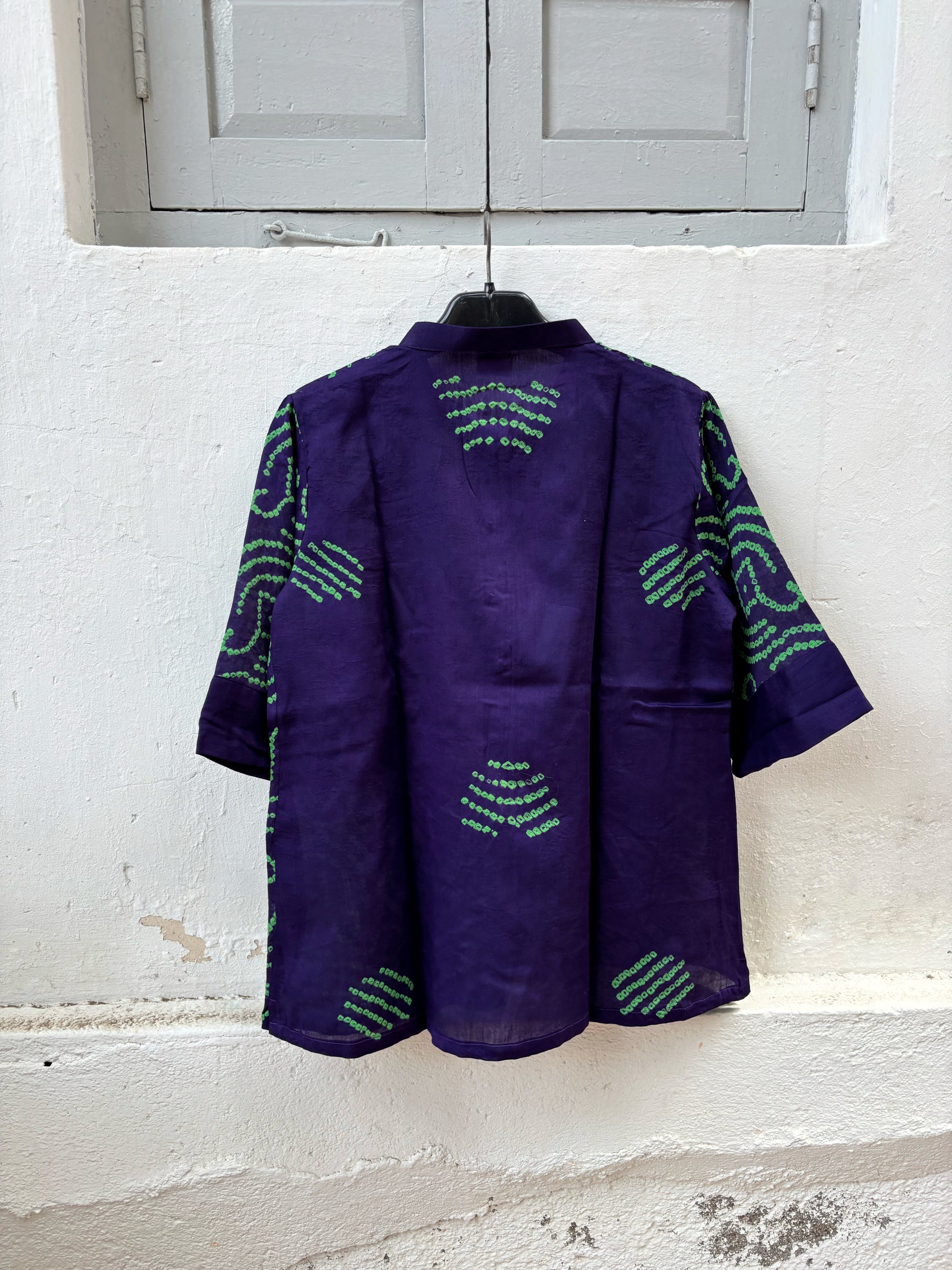 Royal purple Jhankaar Bandhani cotton shirt with vibrant parrot green motifs, soft mandarin collar, folded sleeve cuffs and relaxed fit.