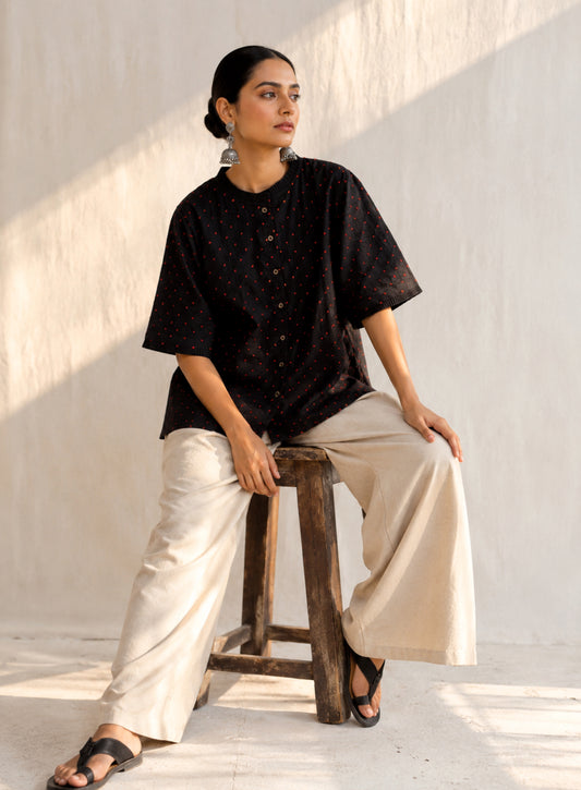 Black cotton satin shirt with burnt orange and deep red hand-tied thread knot detailing, pleated neckline and plain black back.