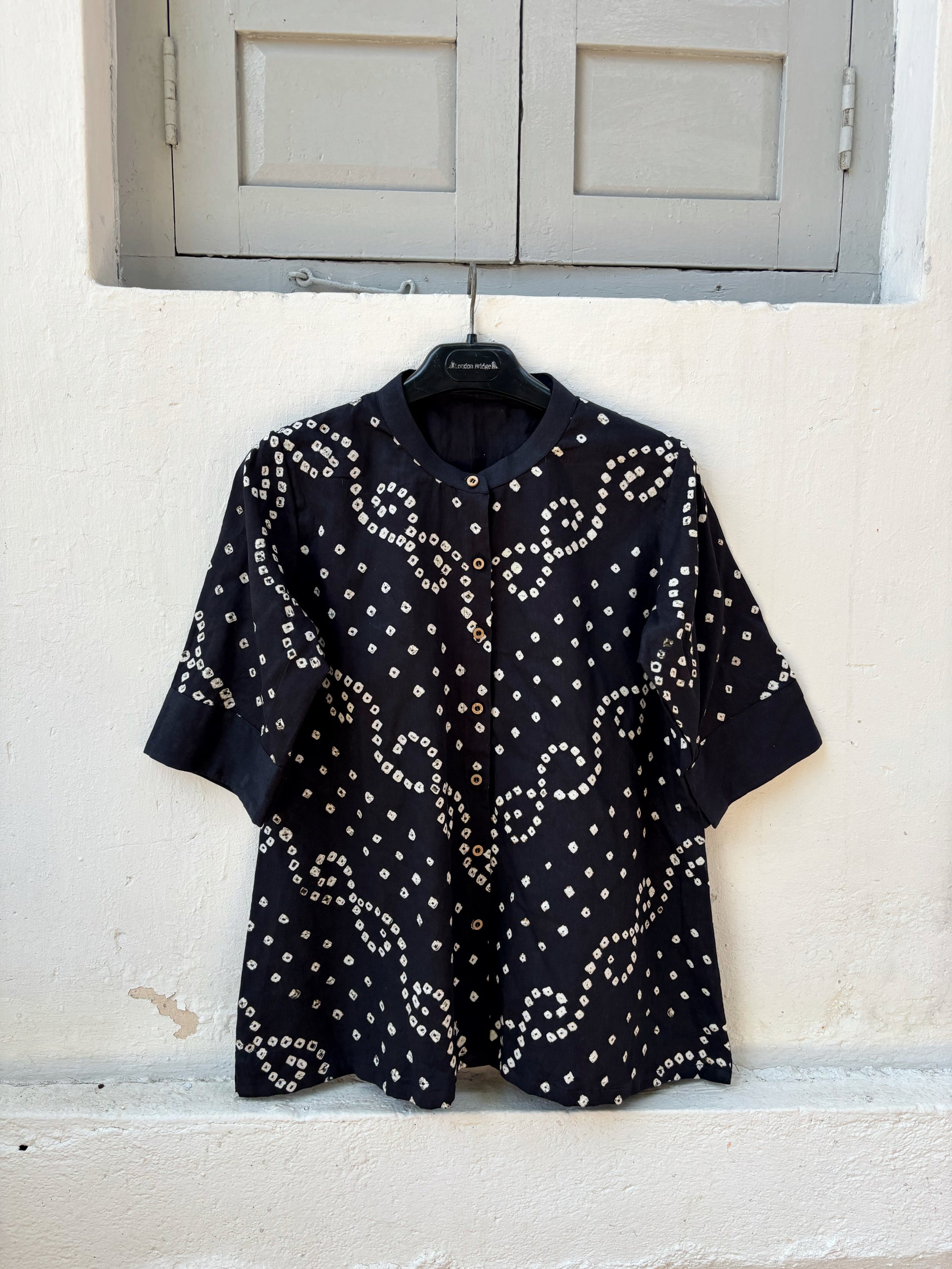 Woman’s black hand tie dyed Bandhani relaxed fit shirt in cotton satin with soft mandarin collar and ivory vine motifs
