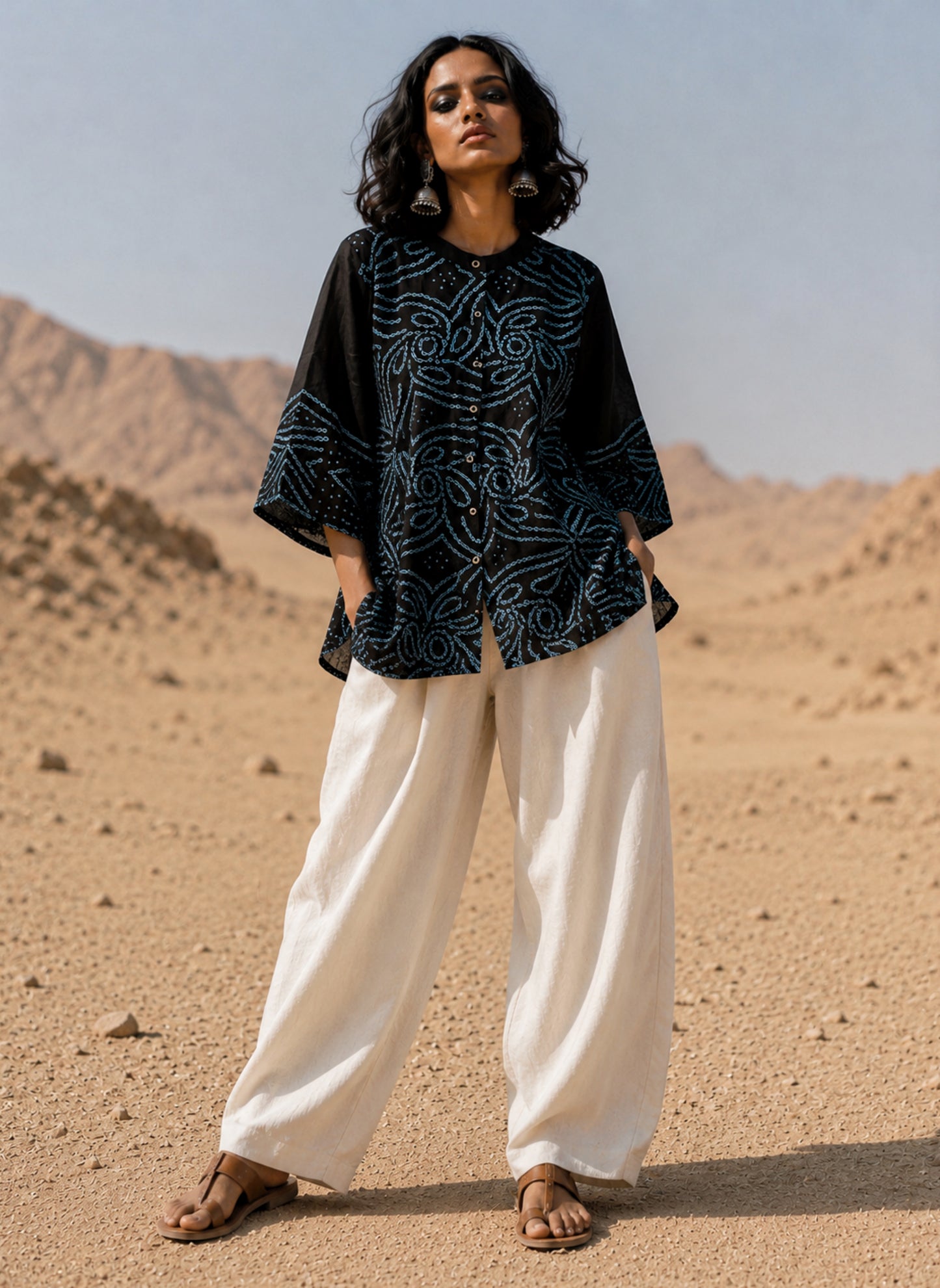 Handmade Jhankar Rai Dani Bandhani cotton shirt in charcoal black with dusty turquoise floral motifs, soft mandarin collar, Bandhani cuffs, relaxed fit, and short side slits.