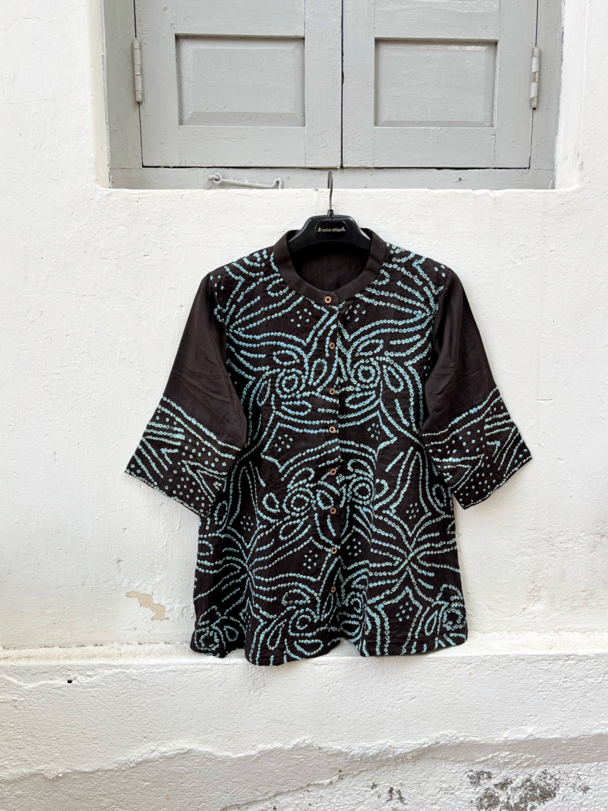 Handmade Jhankar Rai Dani Bandhani cotton shirt in charcoal black with dusty turquoise floral motifs, soft mandarin collar, Bandhani cuffs, relaxed fit, and short side slits.