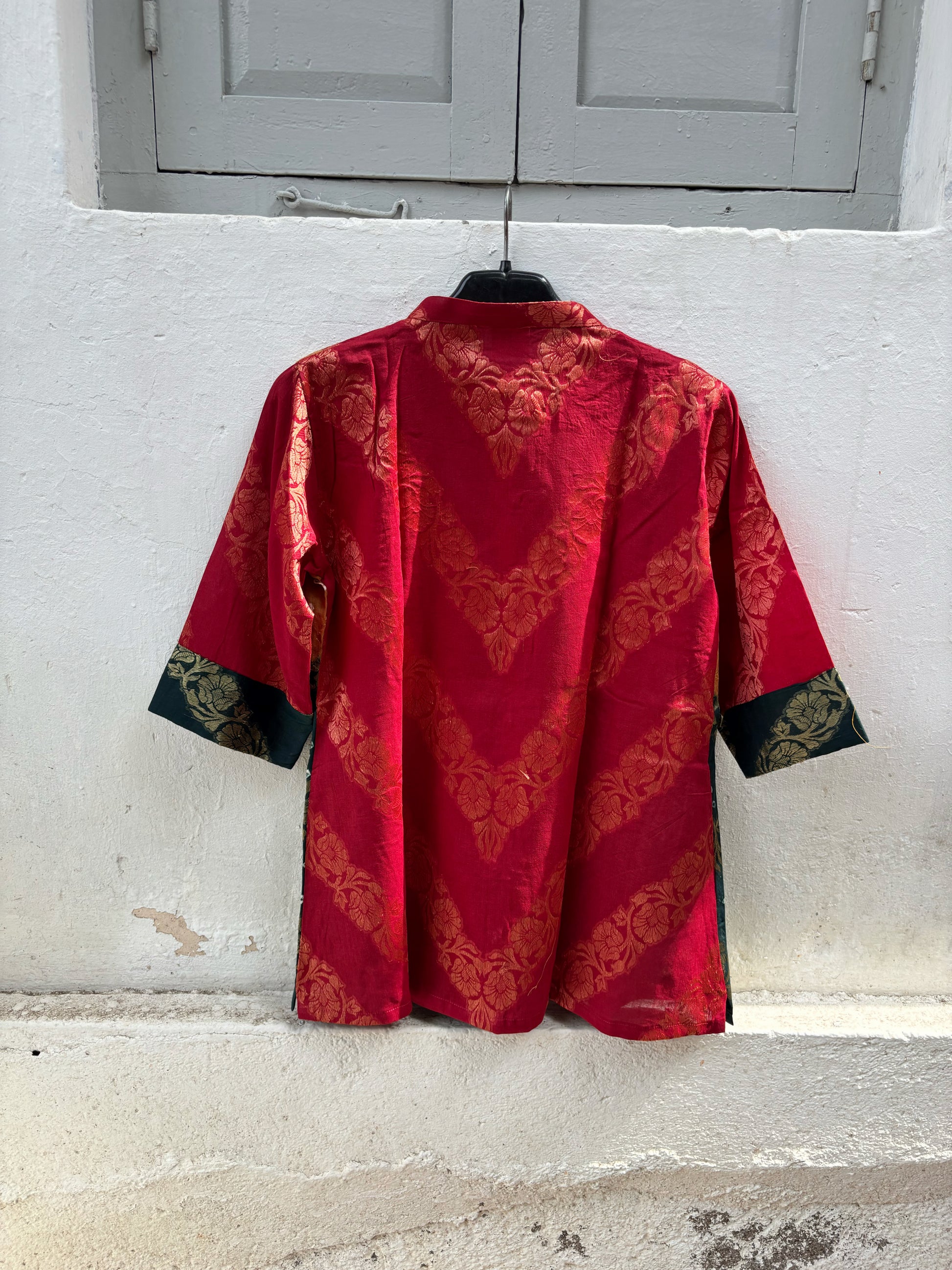 Handcrafted Bandhani festive cotton shirt in Crimson Red, Antique Mustard and Forest Green with antique gold woven floral motifs, mandarin band collar, front button closure, relaxed fit and three-quarter sleeves.
