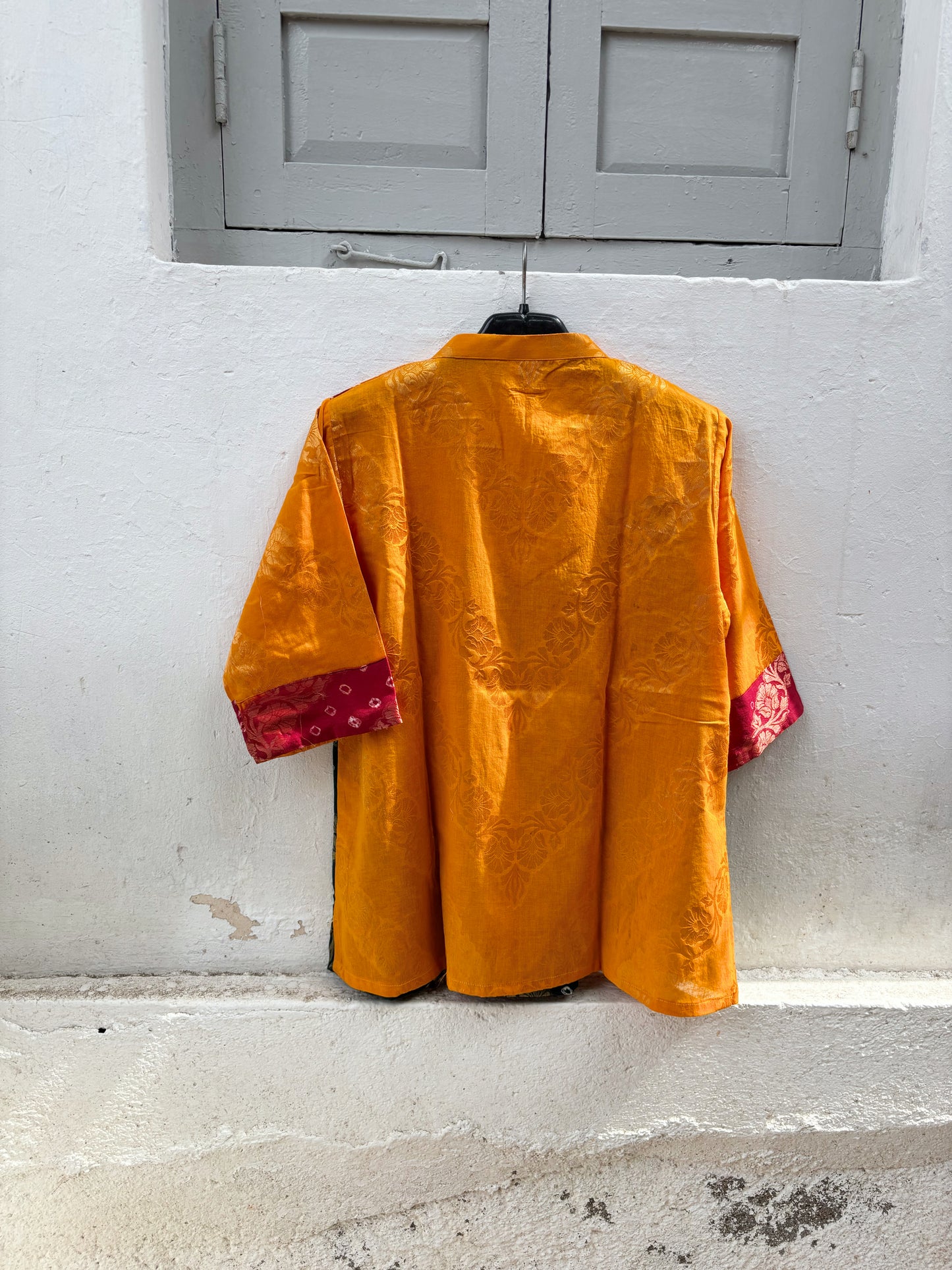 Handcrafted Bandhani festive cotton top in Saffron Yellow, Crimson Red and Deep Teal with antique gold woven floral motifs, mandarin V-neck, relaxed fit and three-quarter sleeves.
