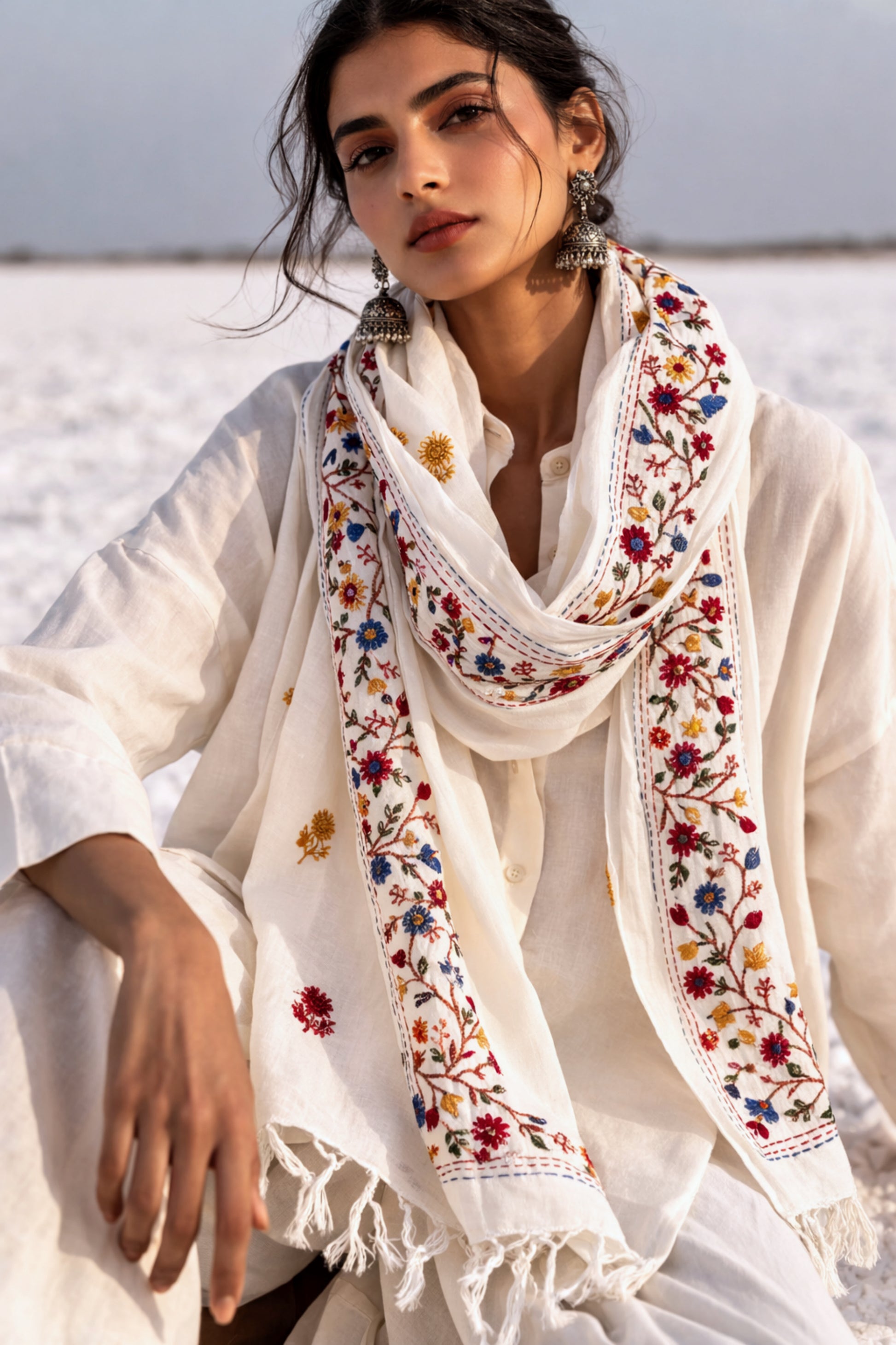 Handspun cotton dupatta in warm ivory shade with detailed floral vine hand embroidery in red, blue, mustard, and green tones. Lightweight, breathable handcrafted dupatta with tassel edges, named Latika.