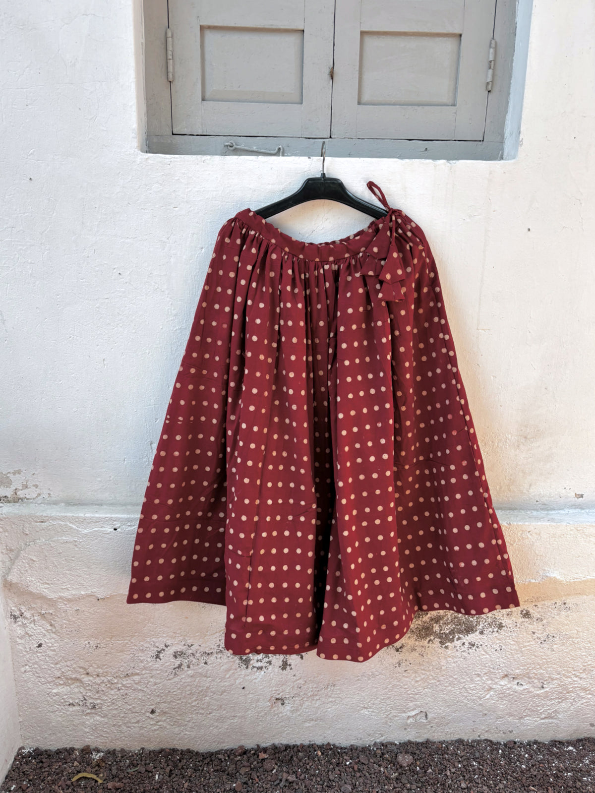Madhu madder-red Ajrakh cotton co-ord set with a sleeveless cropped top and gathered skirt featuring beige hand block printed dots.