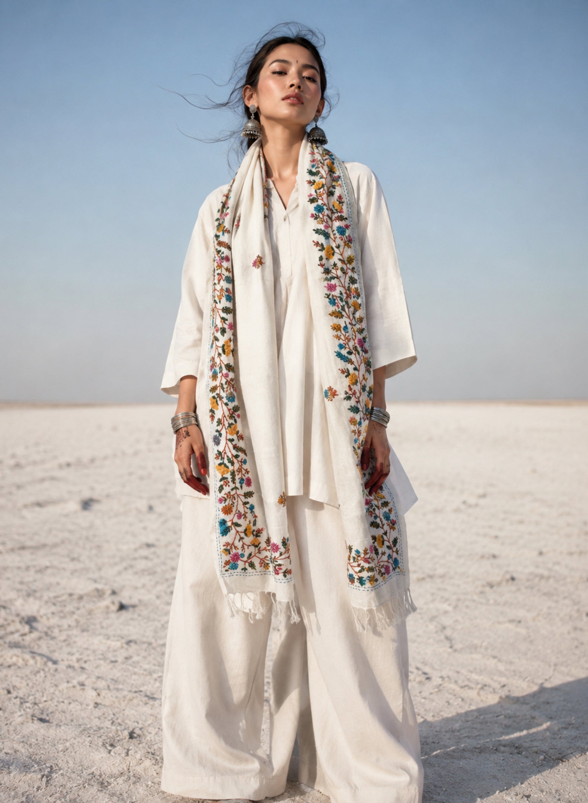 Madhumalti hand spun and handwoven off-white cotton dupatta with multicolour floral embroidered borders, scattered embroidered butis, and handcrafted tassels.

