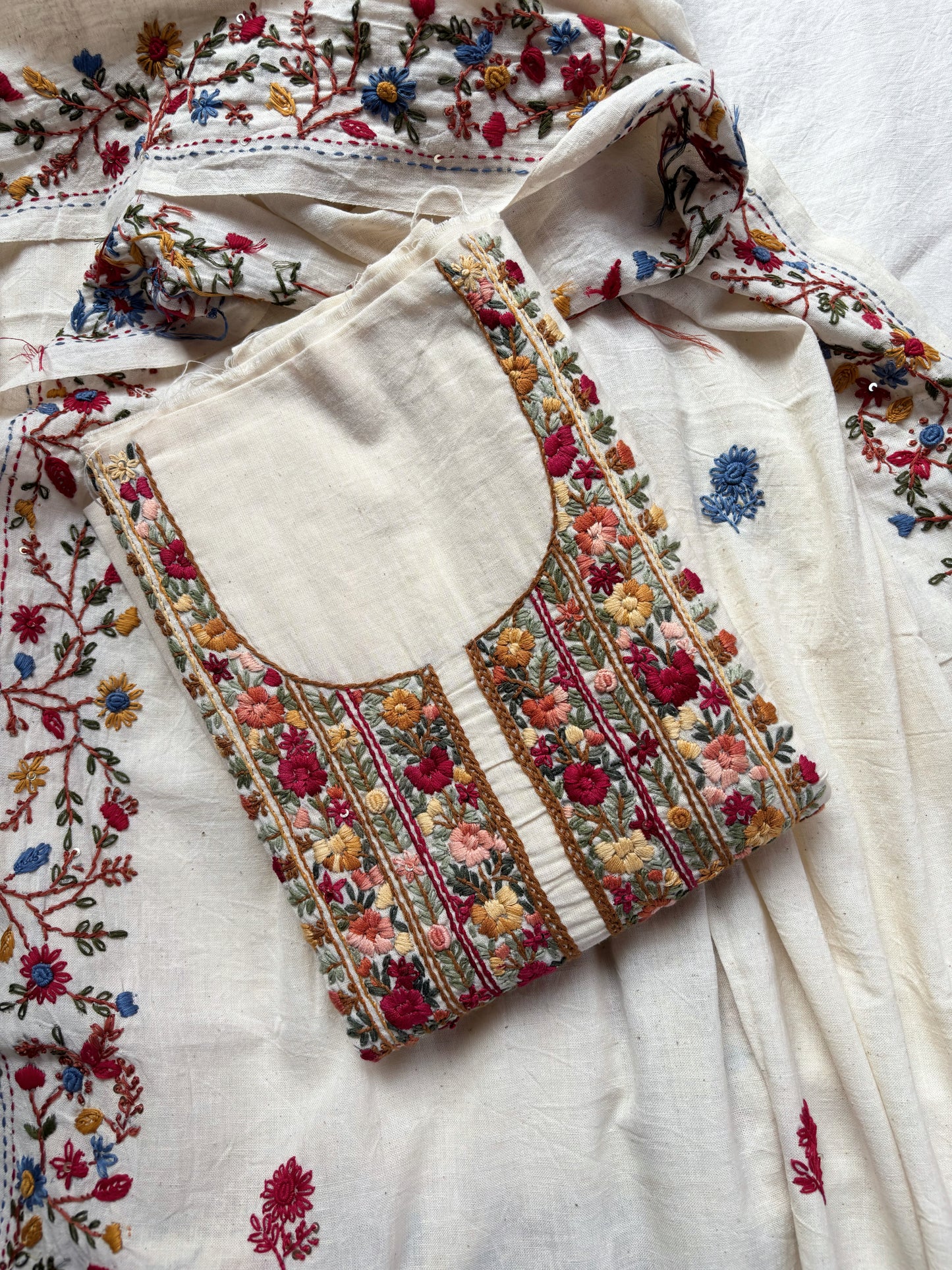 Handspun cotton unstitched kurta dupatta set featuring a richly hand embroidered floral yoke with delicate butti motifs and a matching embroidered dupatta in warm ivory tones.