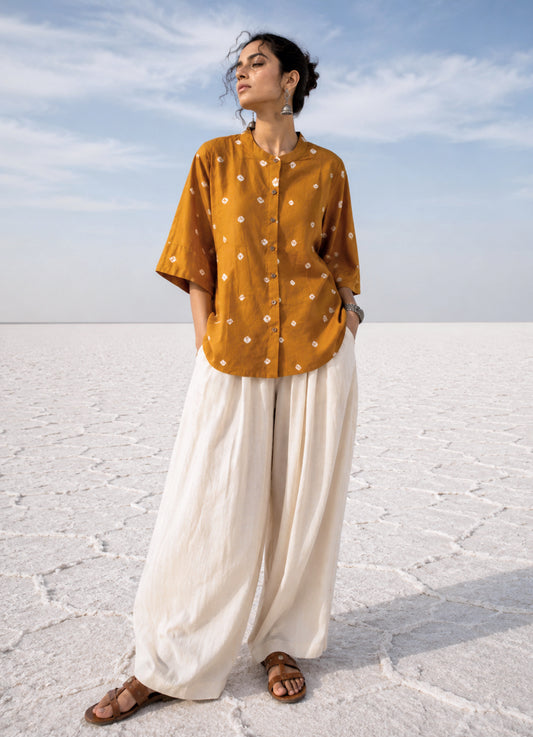 Marigold hand tie-dyed Bandhani cotton satin shirt in warm golden ochre with scattered white Bandhani motifs and a soft mandarin collar.