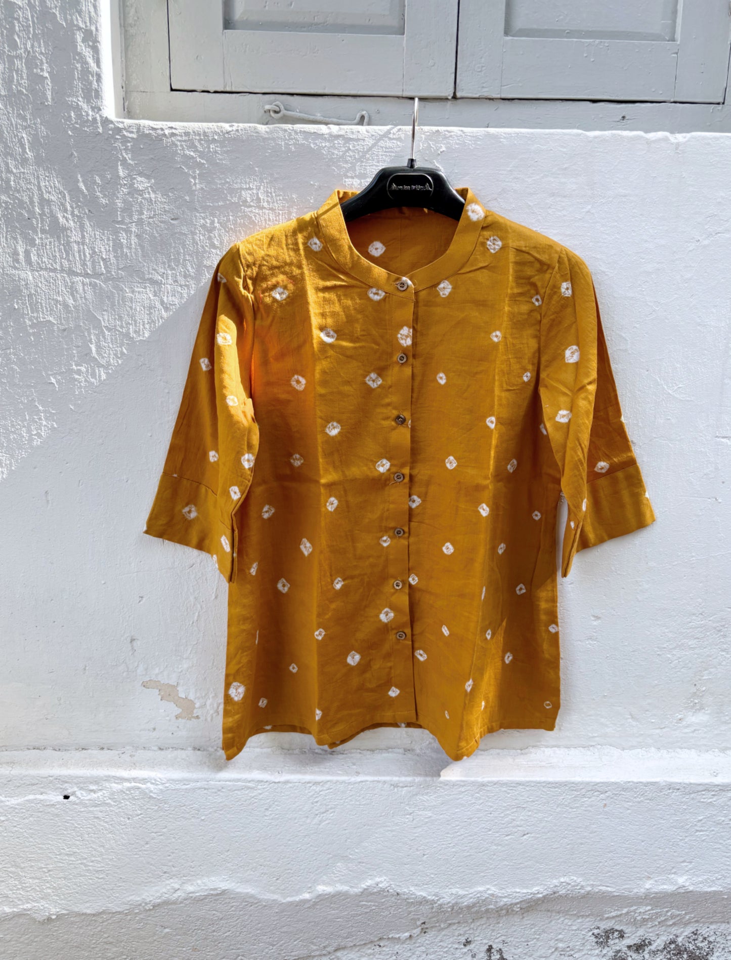 Marigold hand tie-dyed Bandhani cotton satin shirt in warm golden ochre with scattered white Bandhani motifs and a soft mandarin collar.