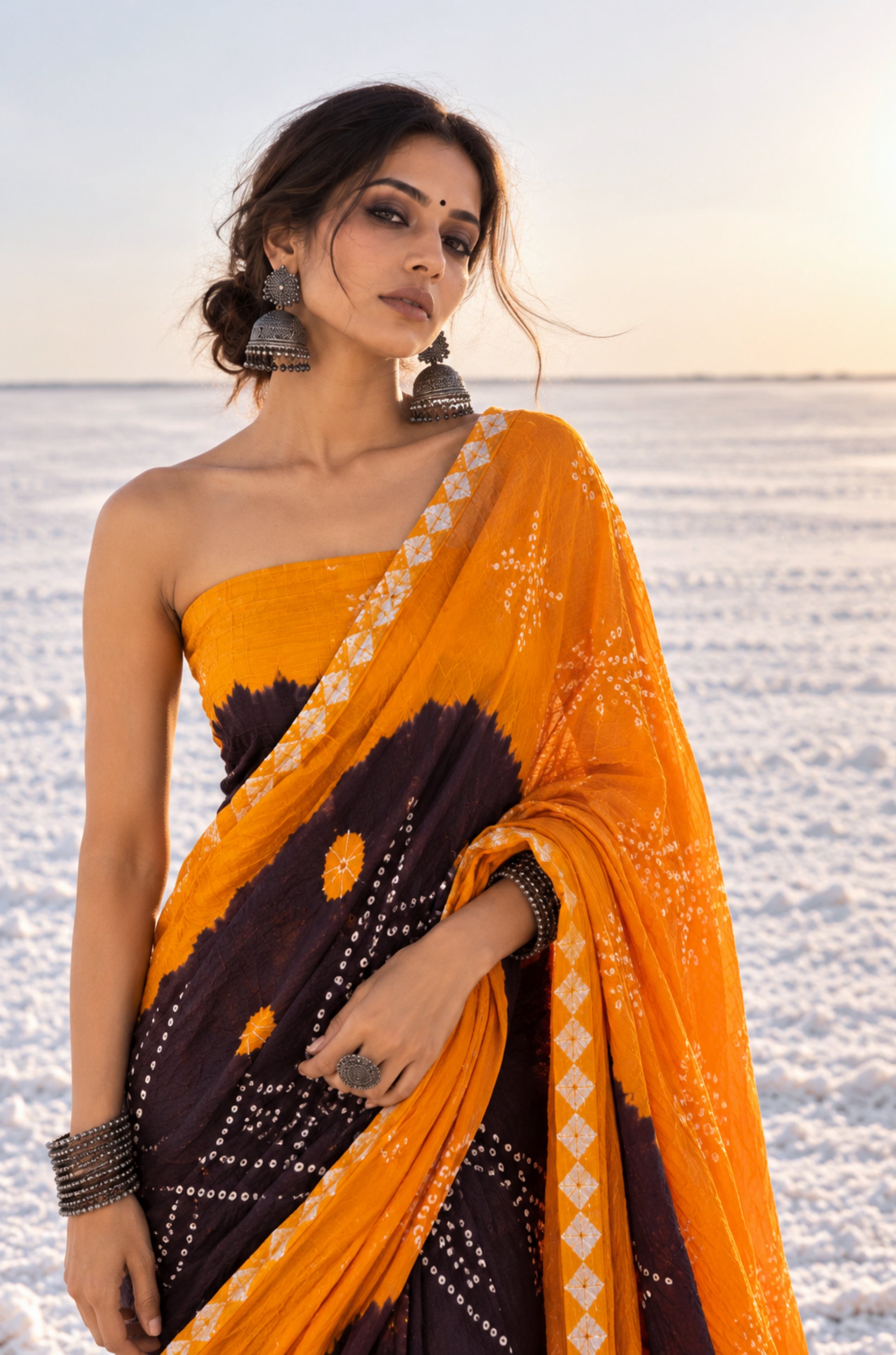Marigold and deep brown hand tie-dyed Bandhani cotton saree with traditional dotted motifs and geometric border