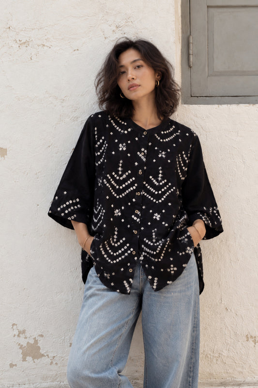Black cotton satin shirt with hand tie-dyed ivory Bandhani, curved geometric motifs, close round neckline and relaxed sleeves by Turquoisethestore.